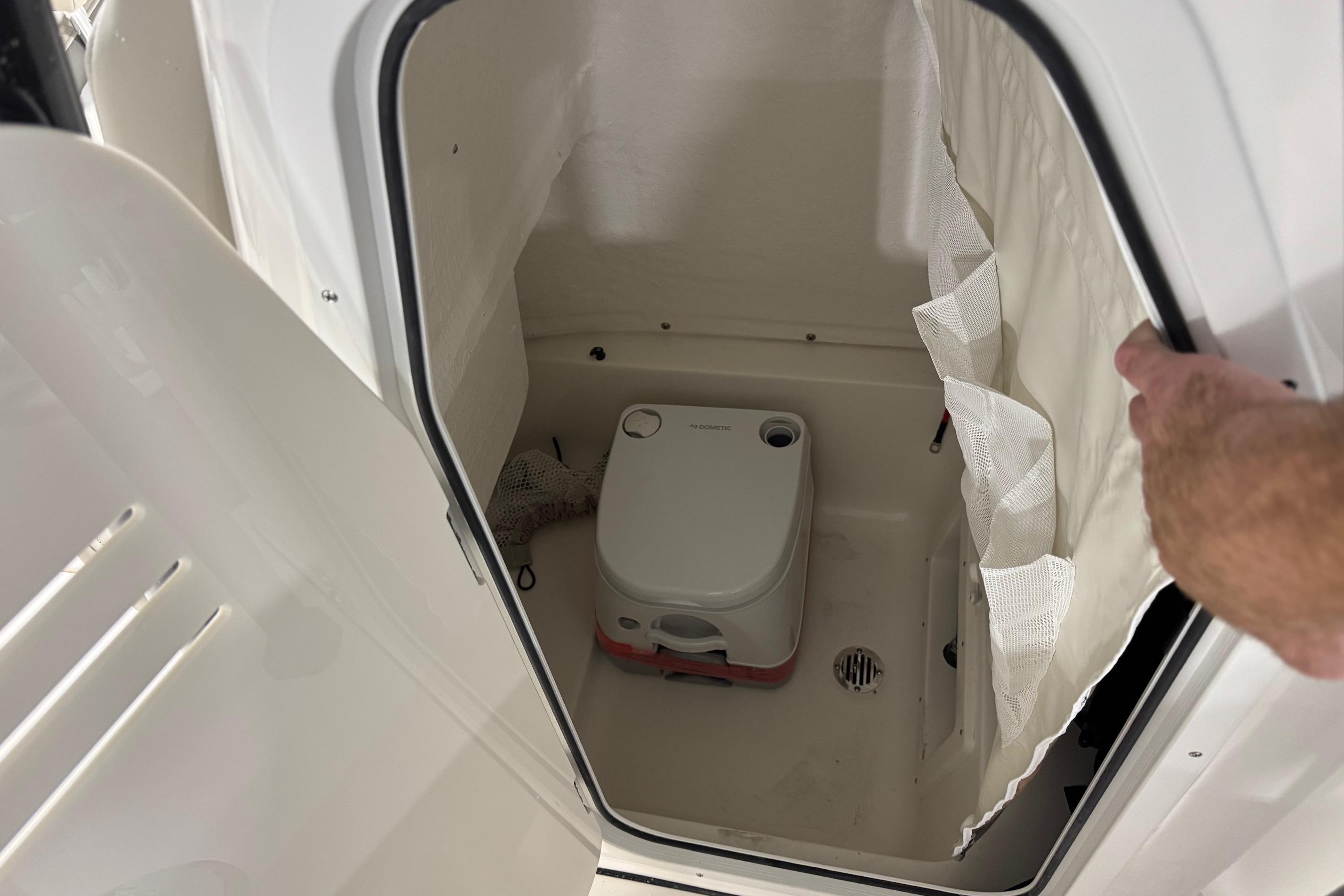 Interior of 2026 Key West 239 FS boat with compact portable toilet.