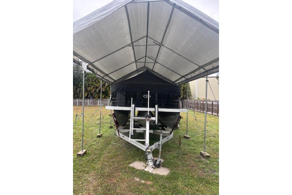2022 Veranda Vista 22RC boat under a metal canopy on grass.
