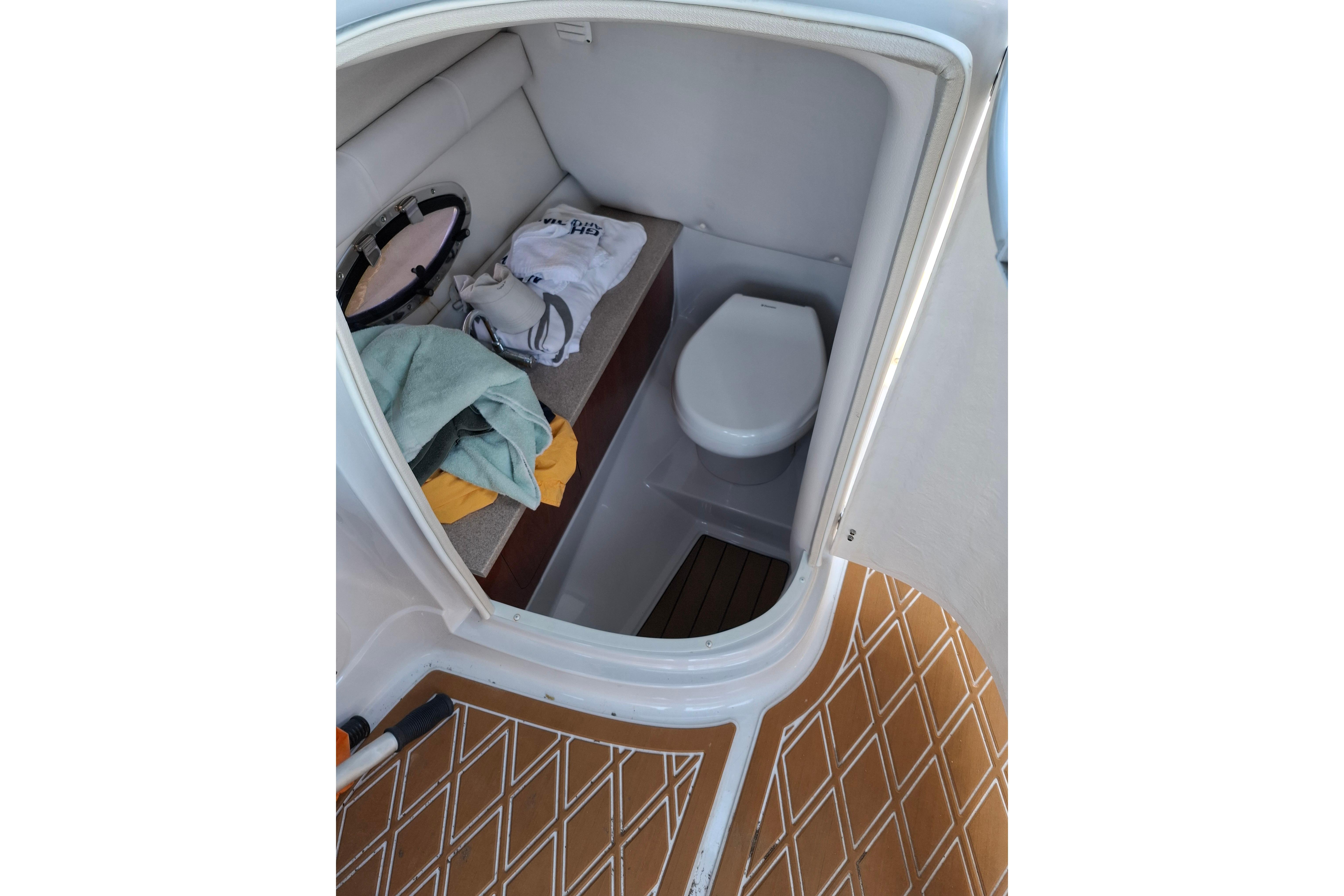 2013 Crownline Eclipse E6 boat interior with compact toilet and storage area.
