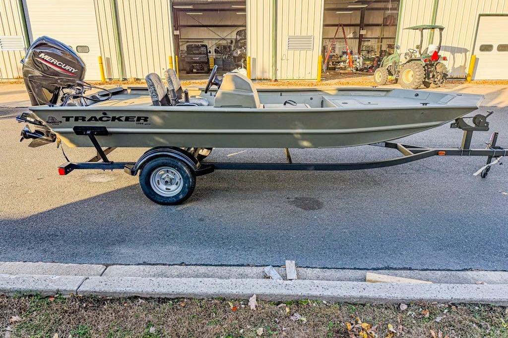 2026 Tracker Grizzly 1754 SC boat on trailer, parked outside a warehouse.
