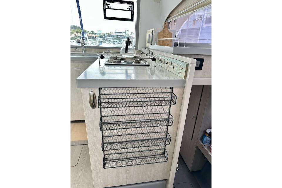 Modern kitchen area in a 2017 Leopard 40 yacht with wire storage racks.