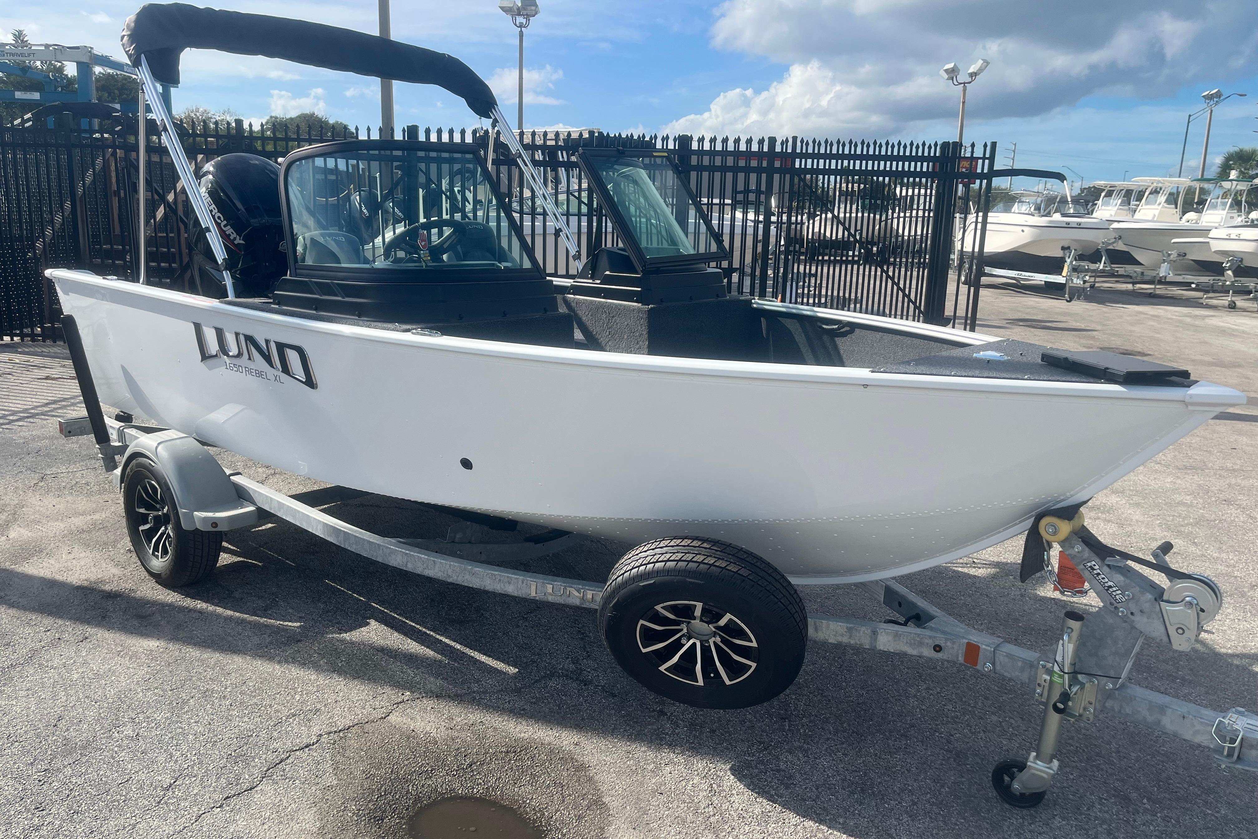2026 Lund 1650 Rebel XL Sport boat on trailer, parked outdoors.