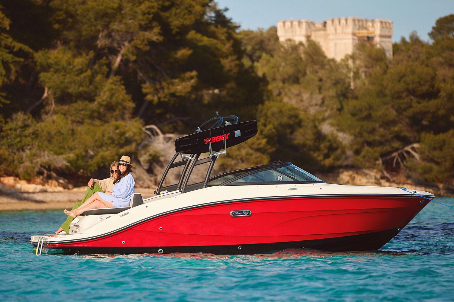 Manufacturer Provided Image: 2025 Sea Ray SPX 210 boat cruising on clear water near a forested shoreline.