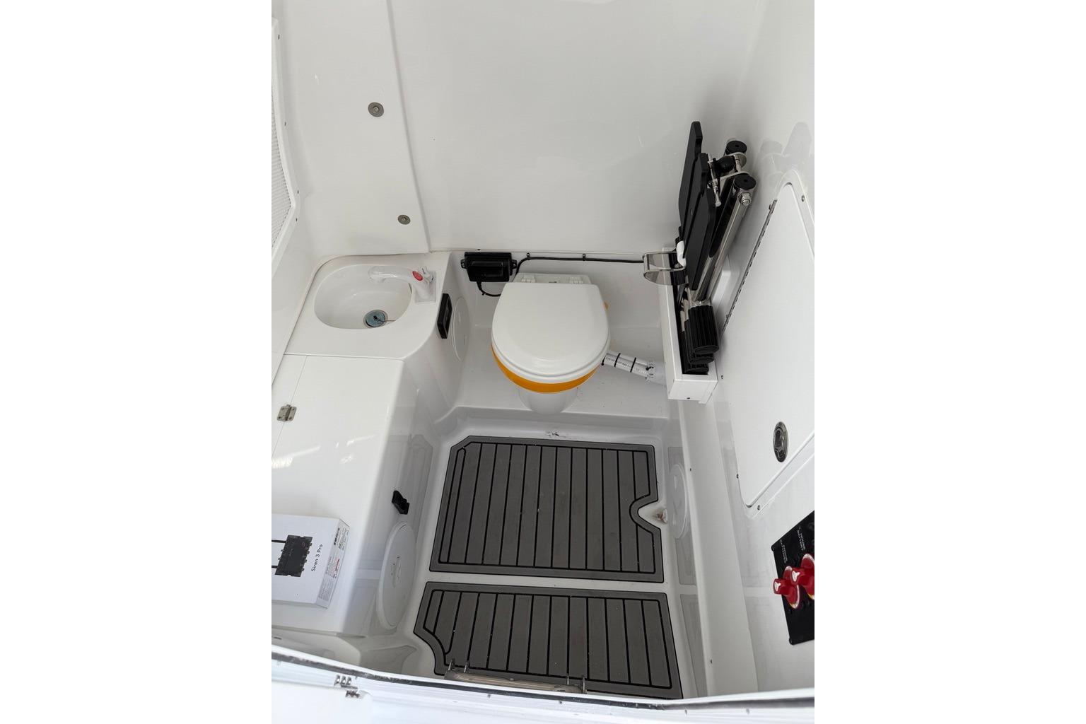 Interior of 2026 Sea Hunt Ultra 285 Coffin Box boat, featuring a compact bathroom setup.