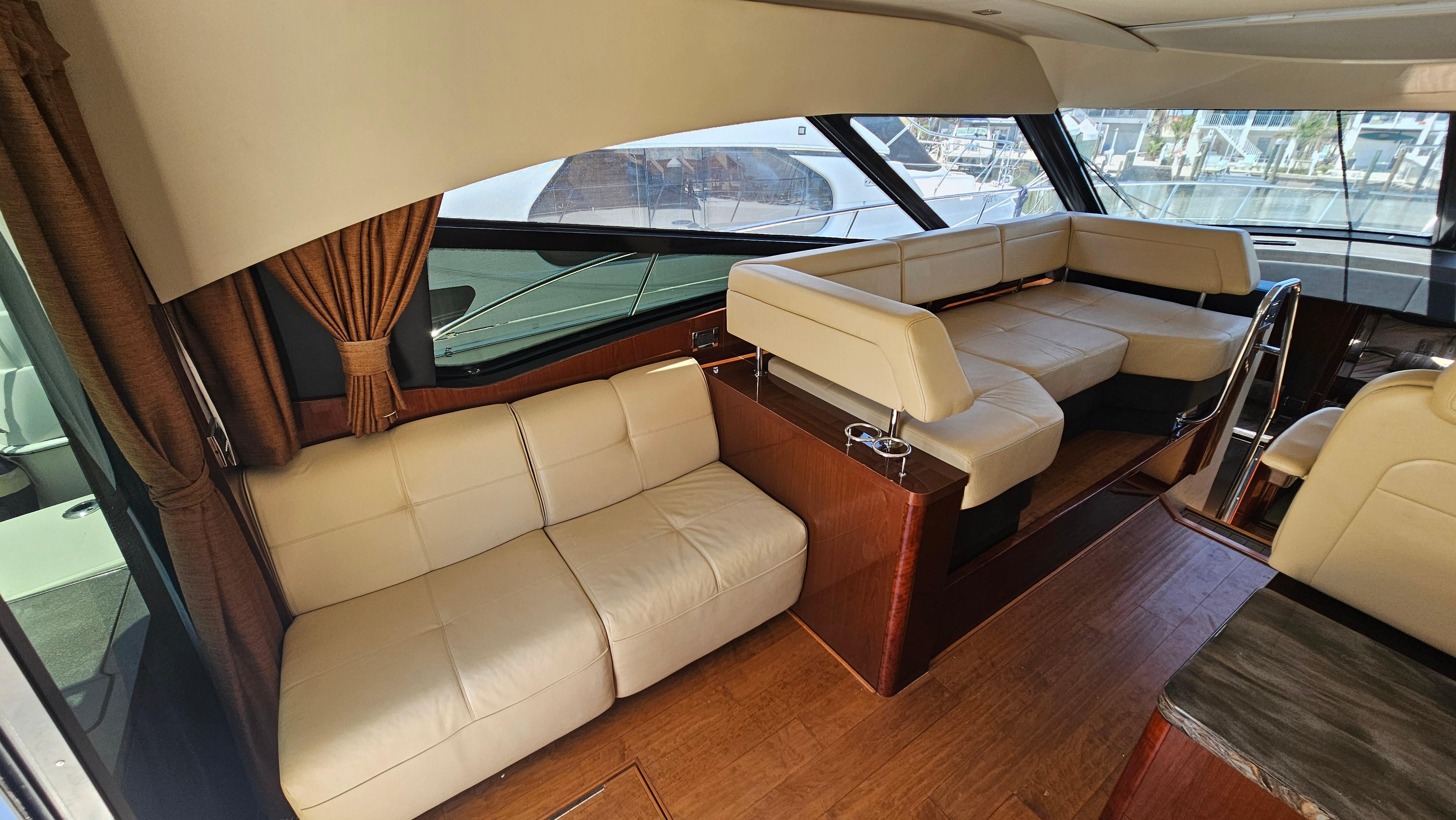 Interior of 2016 Sea Ray 470 Sundancer yacht with beige leather seating and wooden flooring.