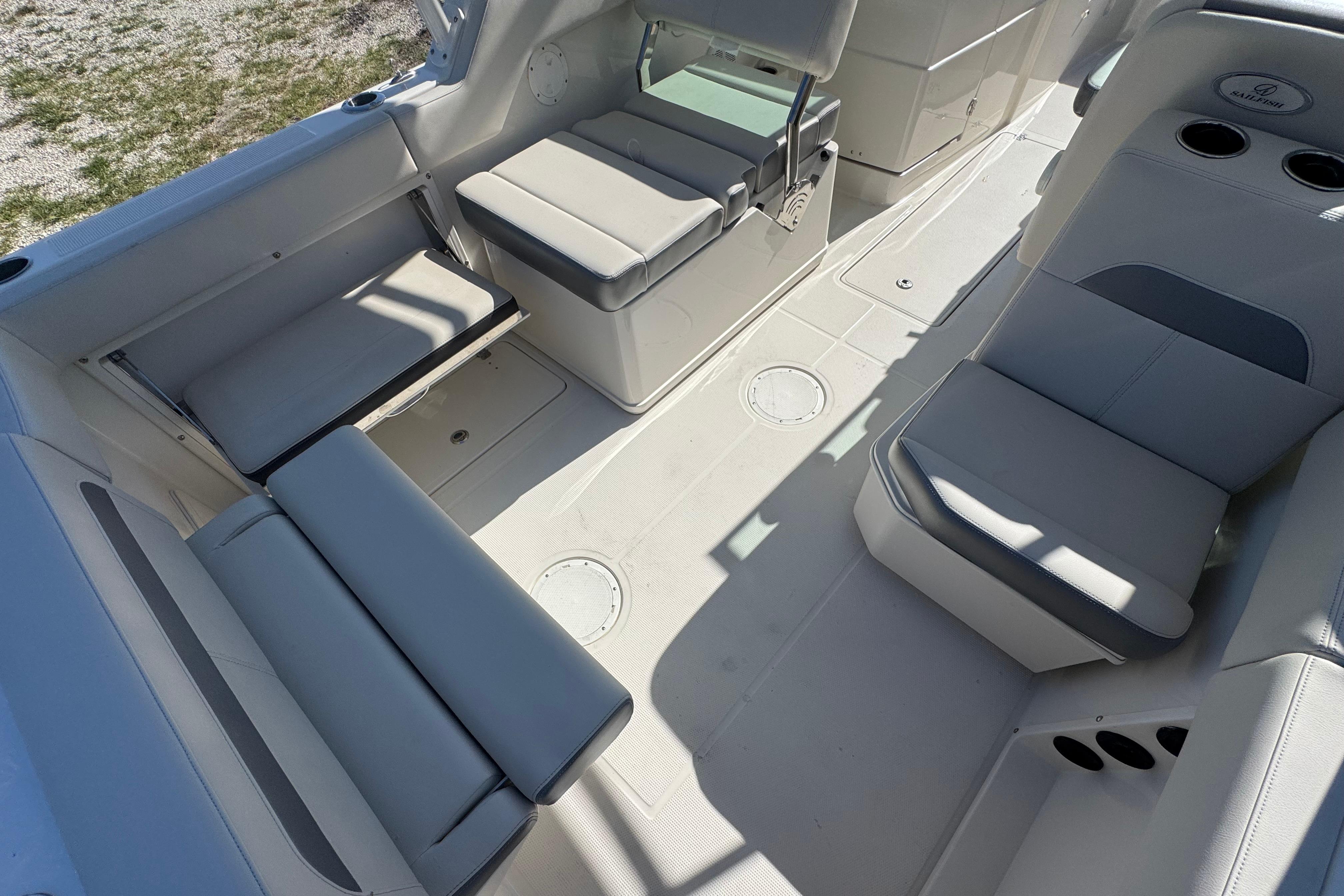 Interior seating of 2023 Sailfish 245 DC boat, featuring cushioned seats and cup holders.