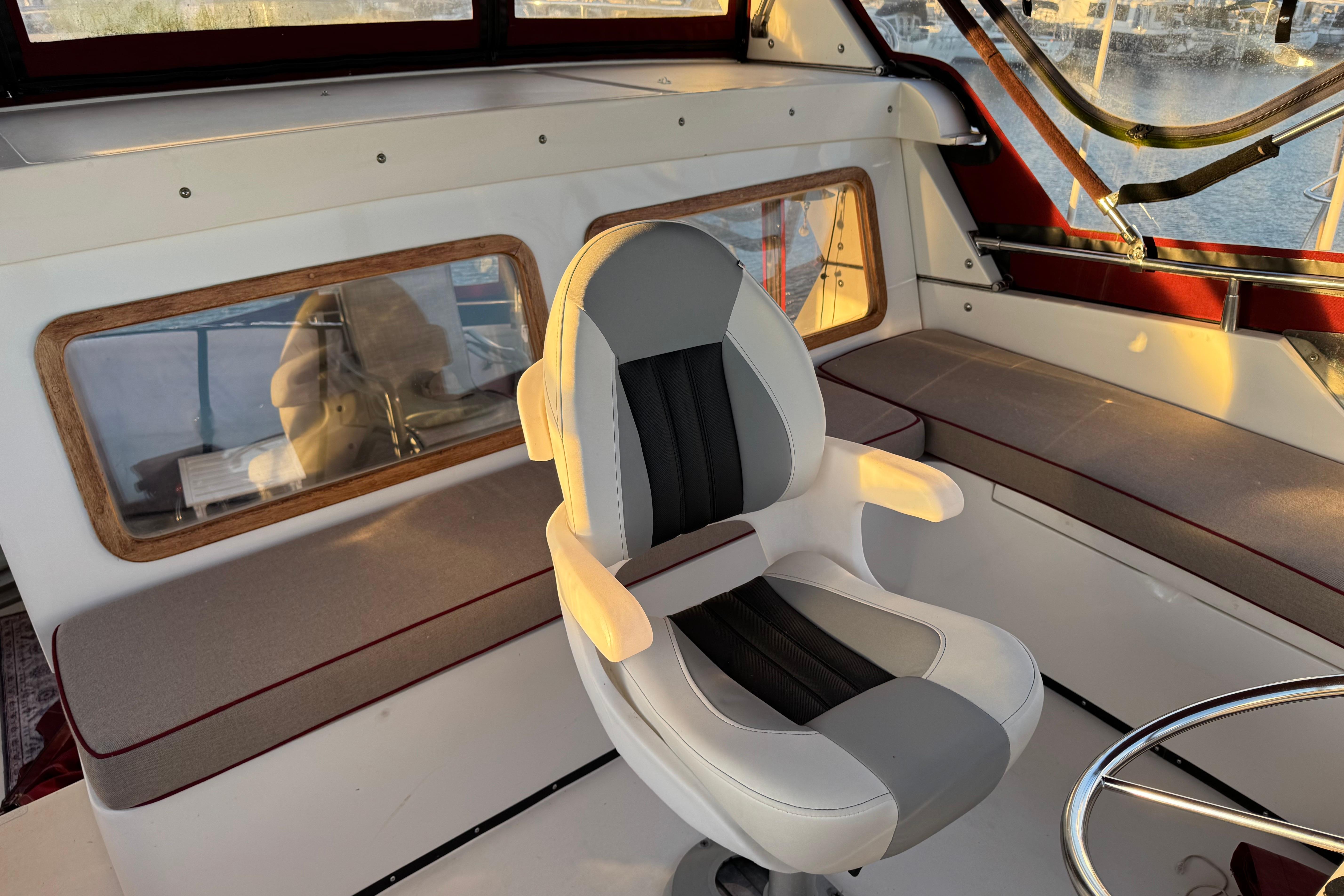 Interior of a 1987 President 37 boat with a modern captain's chair and panoramic windows.