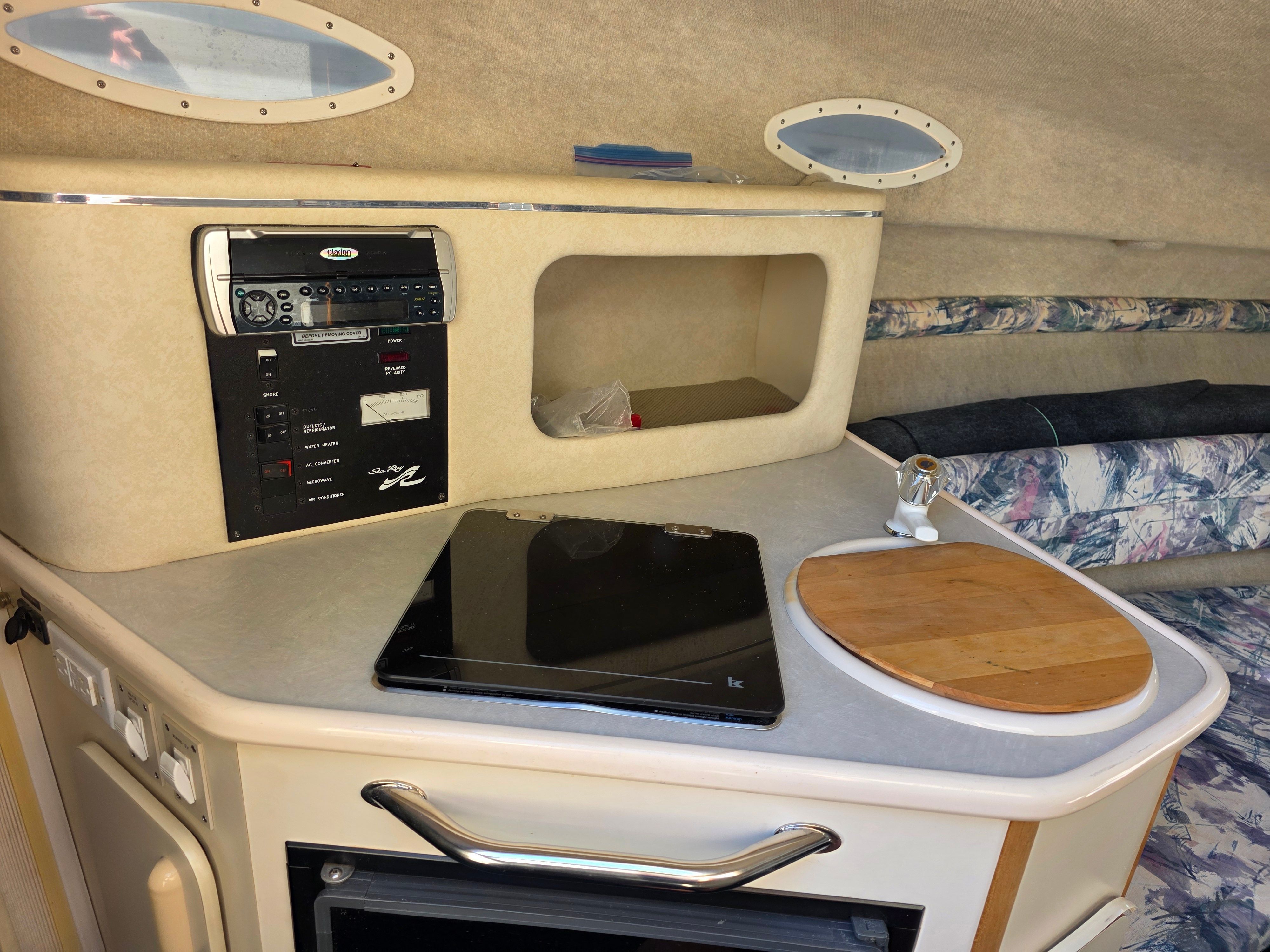 Interior of a 1997 Sea Ray 240 Sundeck with kitchenette and seating area.