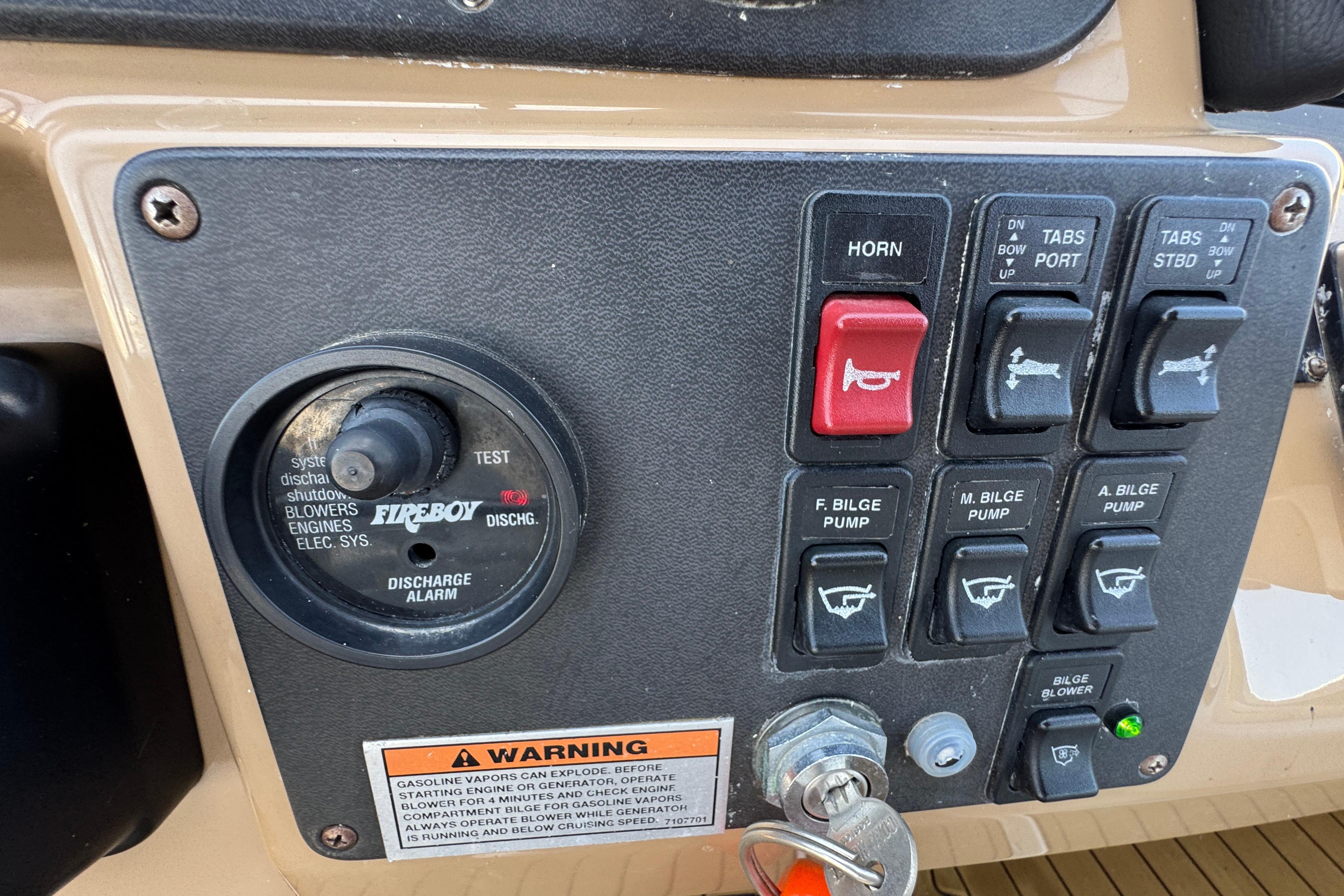 Control panel of a 2002 Carver 396 Motor Yacht with various switches and warning label.