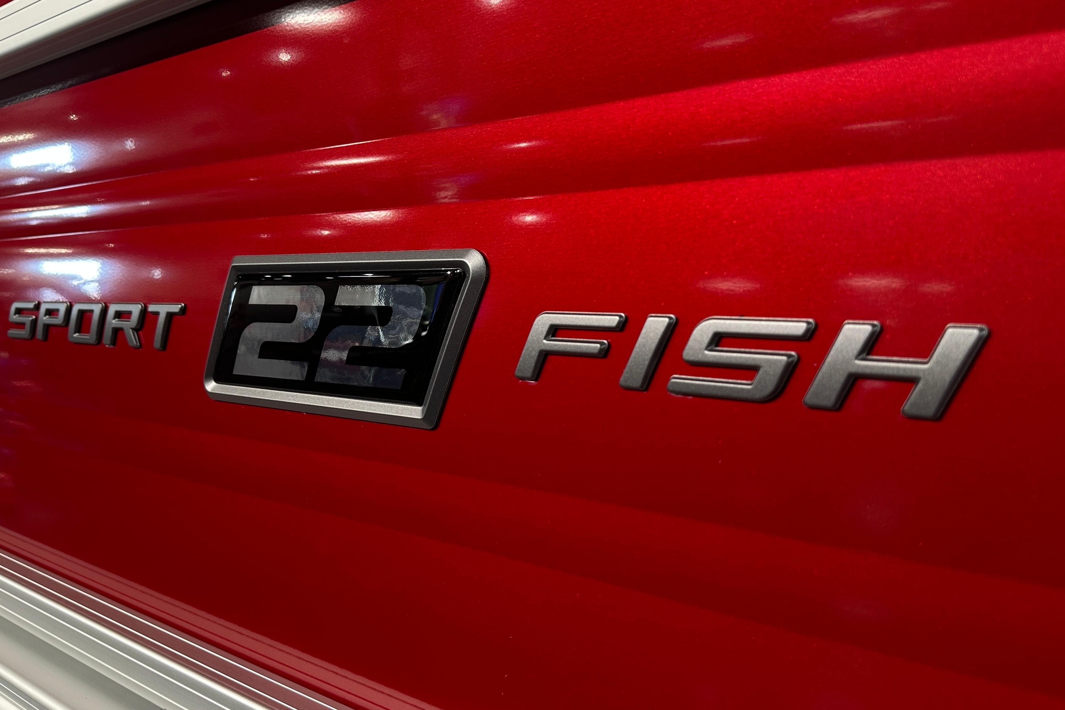2026 Sun Tracker SportFish 22 DLX logo on red boat exterior.