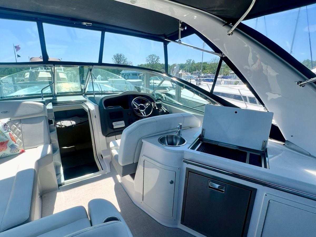 The image shows the cockpit of a 2021 Regal 33 Express with sleek seating and a sink.