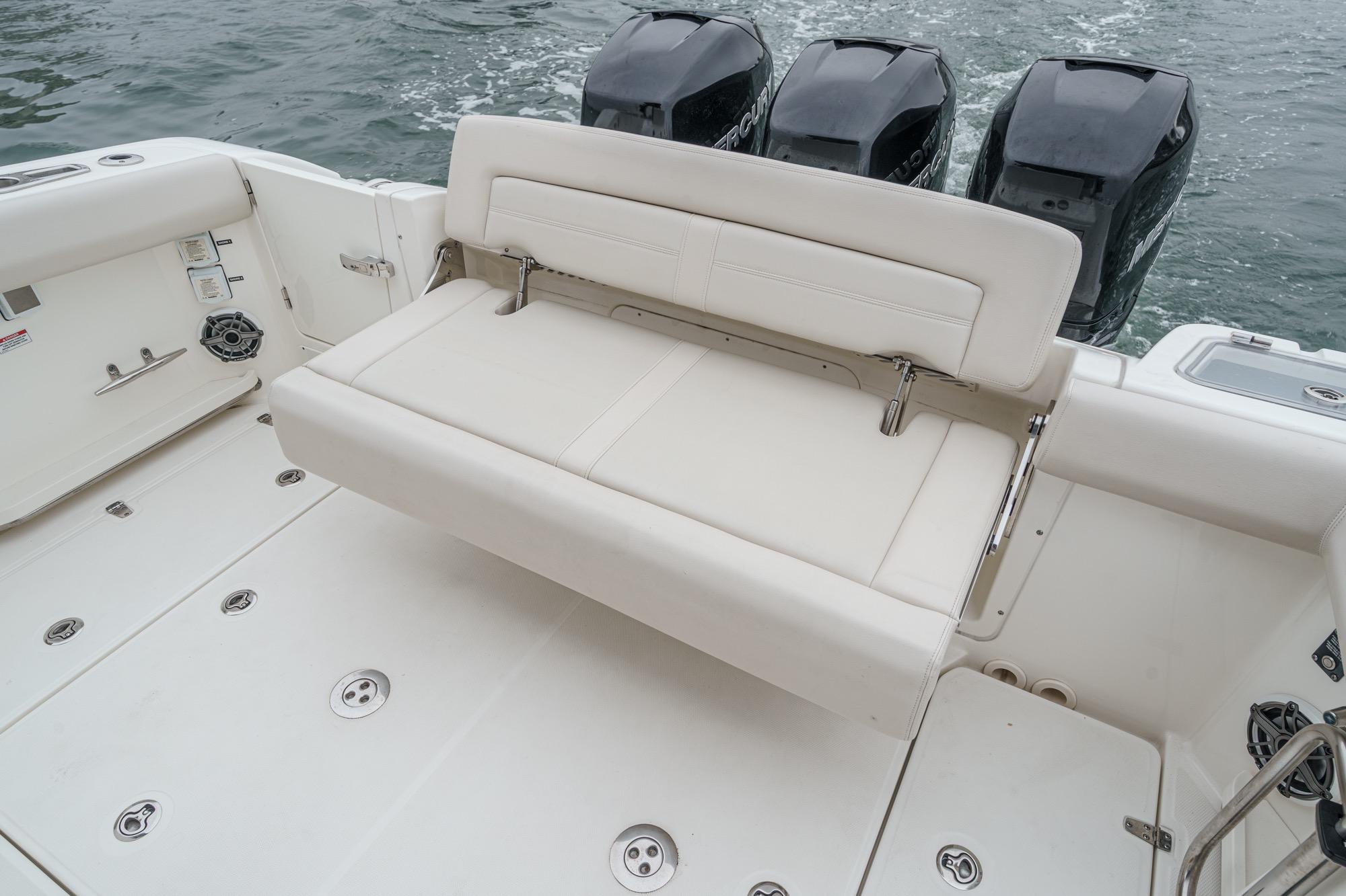 2022 Boston Whaler 350 Realm boat with cushioned seating and triple outboard engines.
