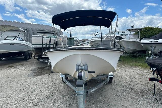 1989 Henry O 150 Dual Console boat on trailer, parked outdoors under a cloudy sky.