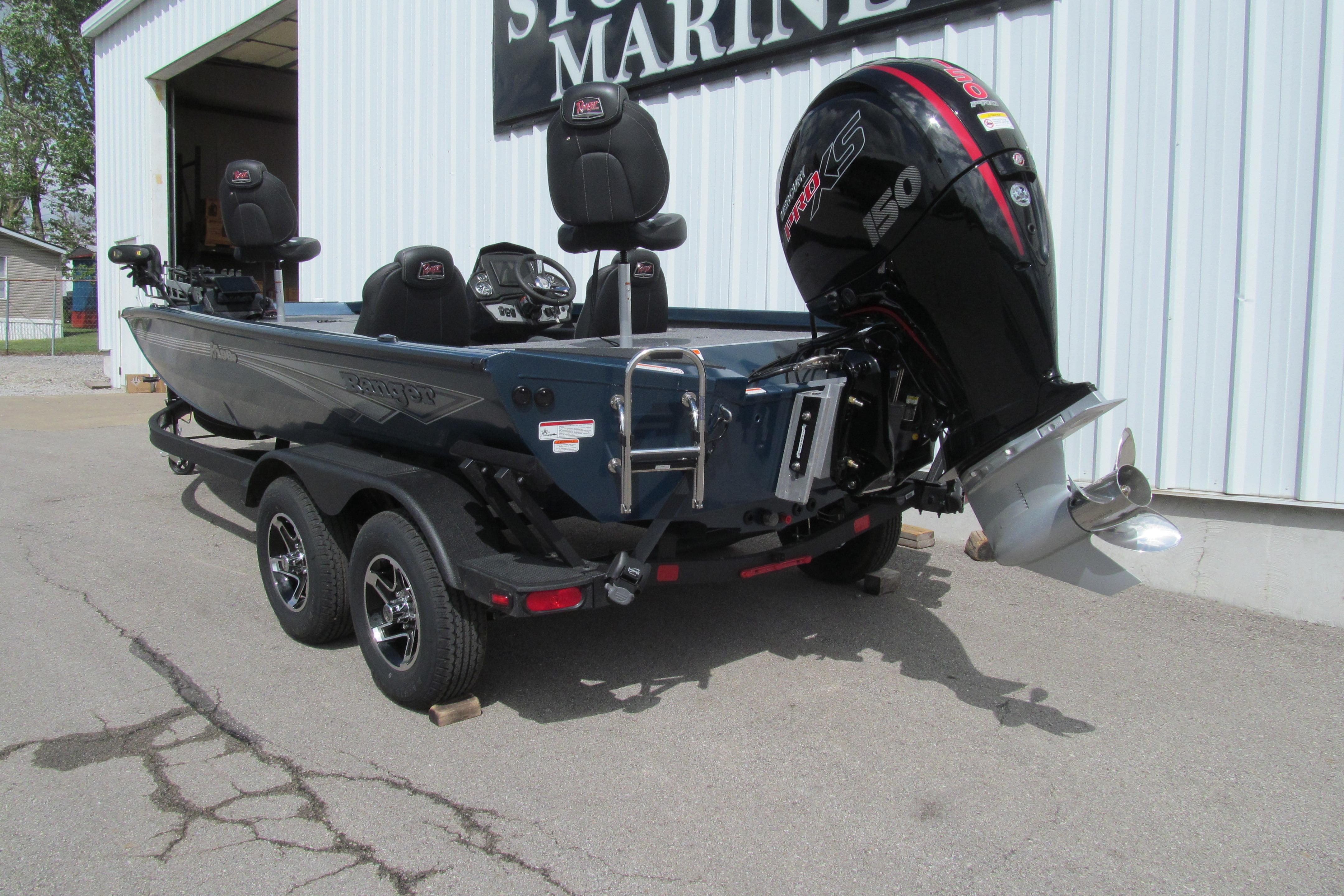 2026 Ranger RT198P boat with powerful outboard motor, parked outside a marine store.
