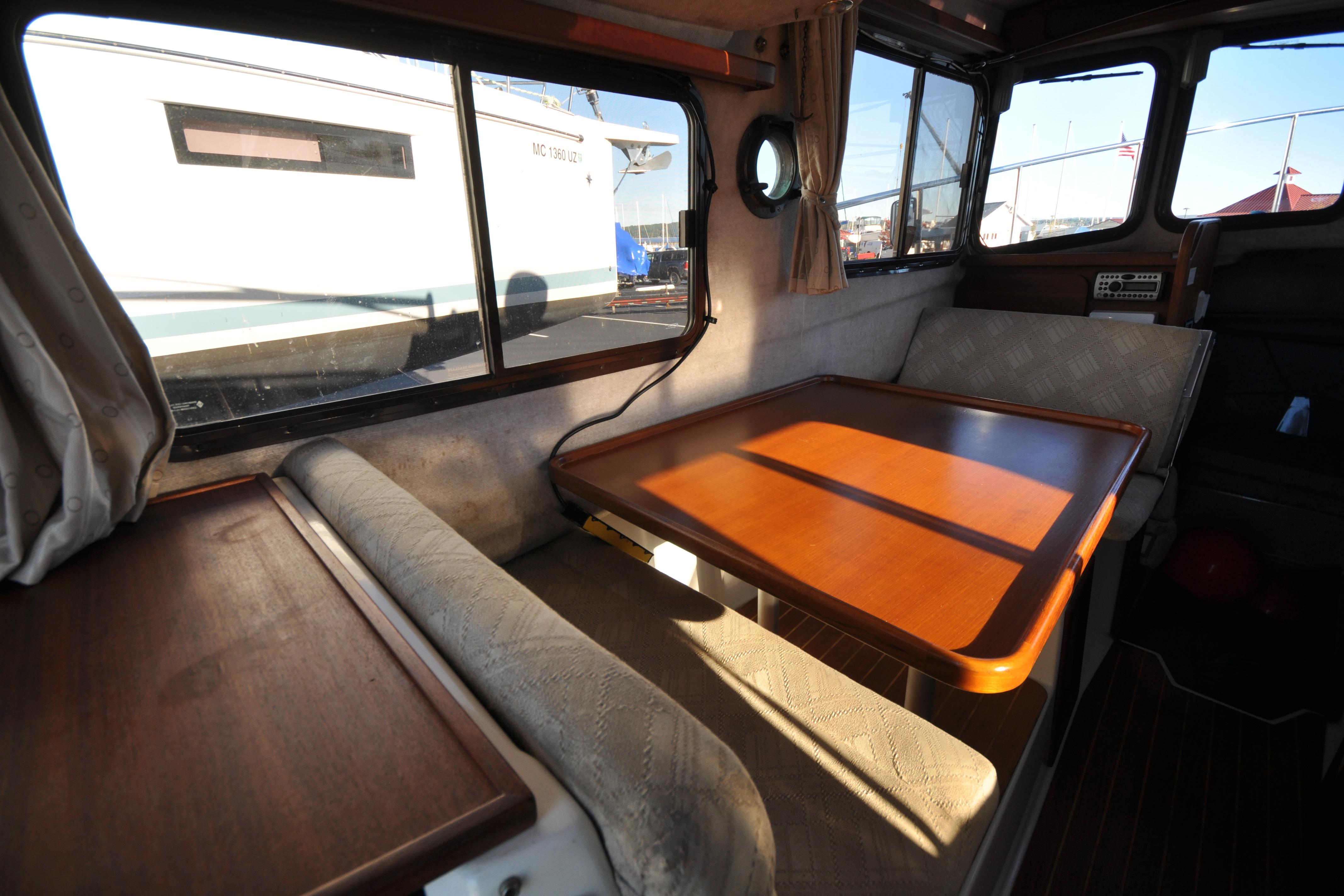 Interior of 2007 Ranger Tug R-25, featuring a cozy dining area with wooden table.