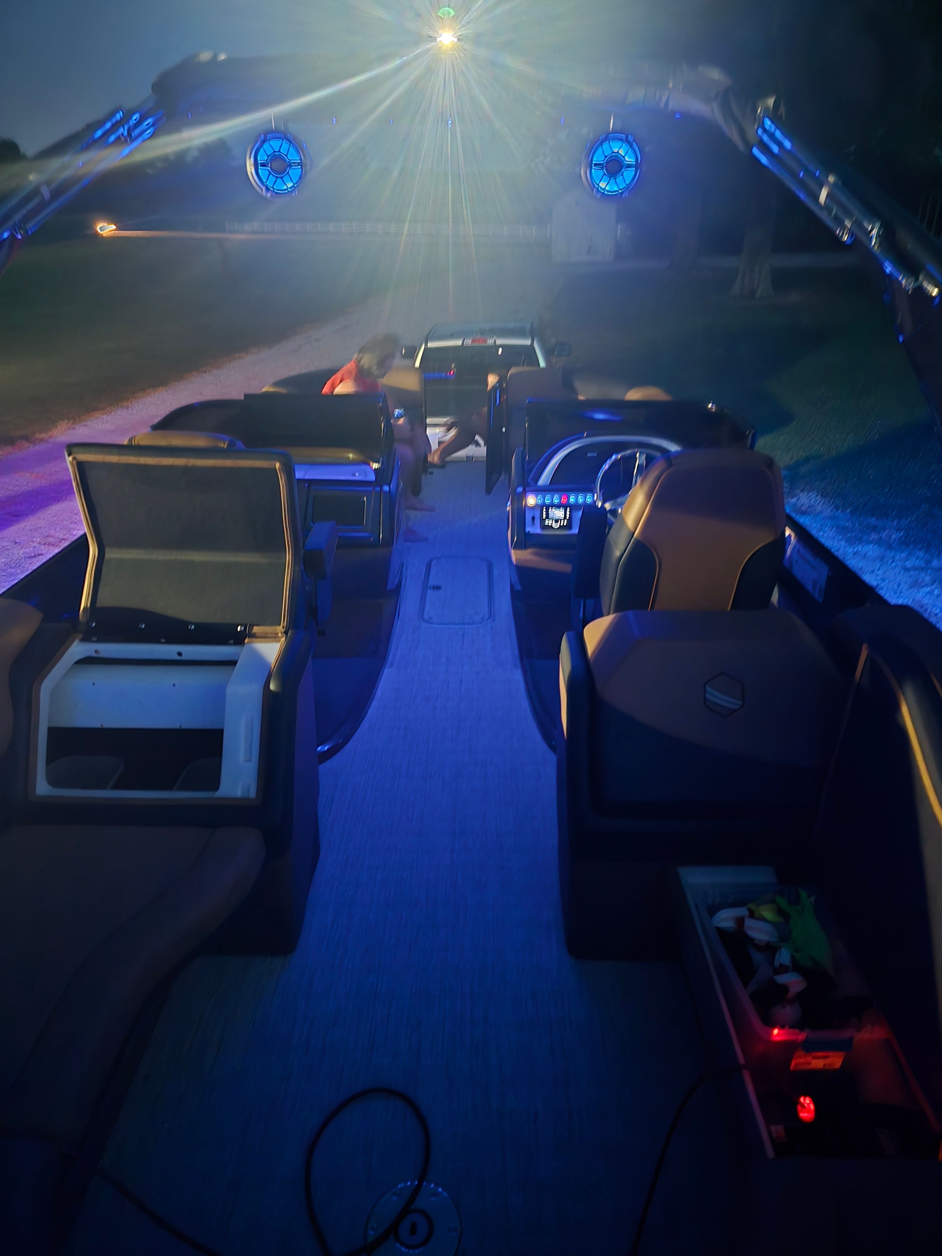 The image shows the interior of a modern boat with blue lighting and sleek seating.