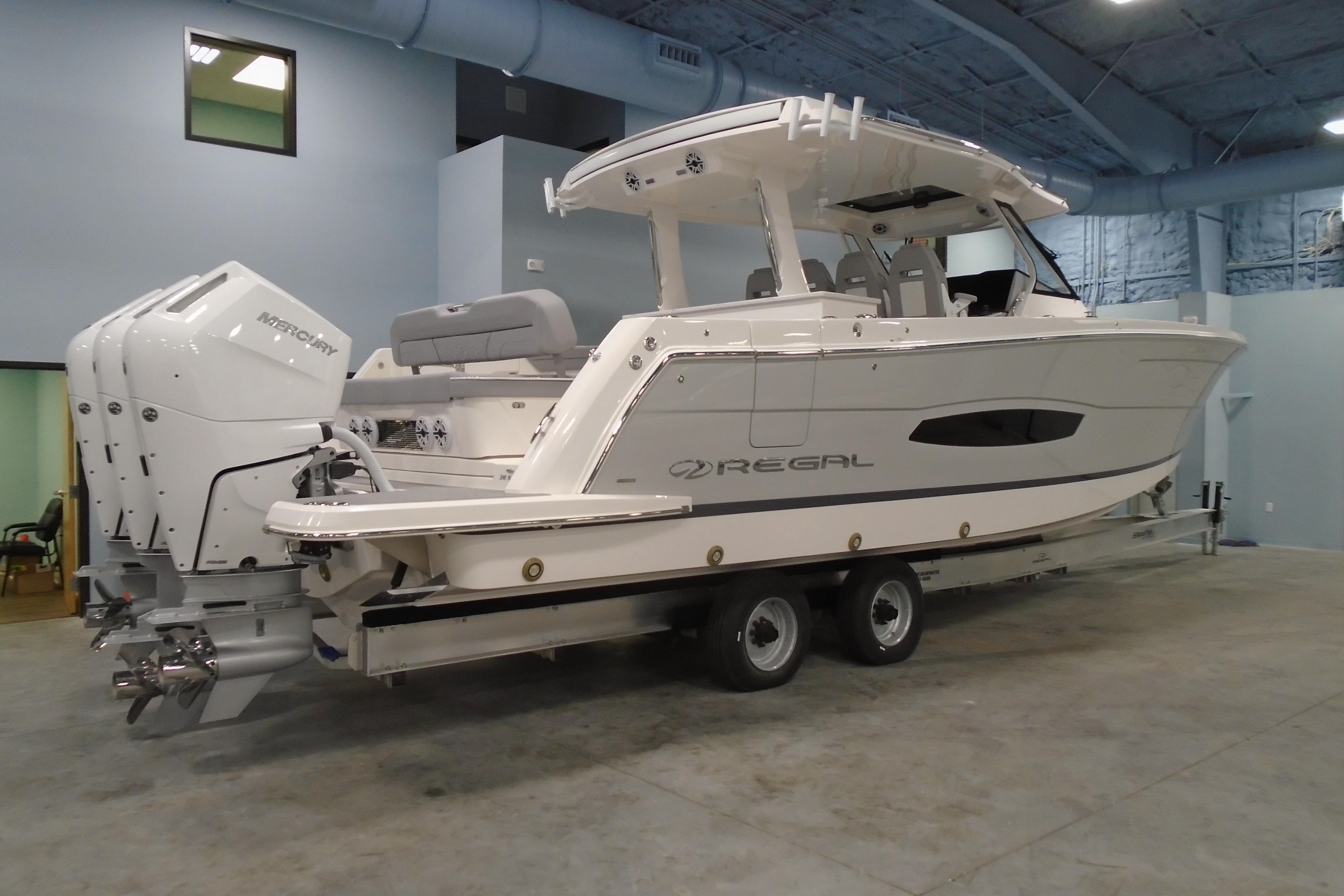 2026 Regal 38 SAV boat with triple Mercury outboard engines in a showroom.