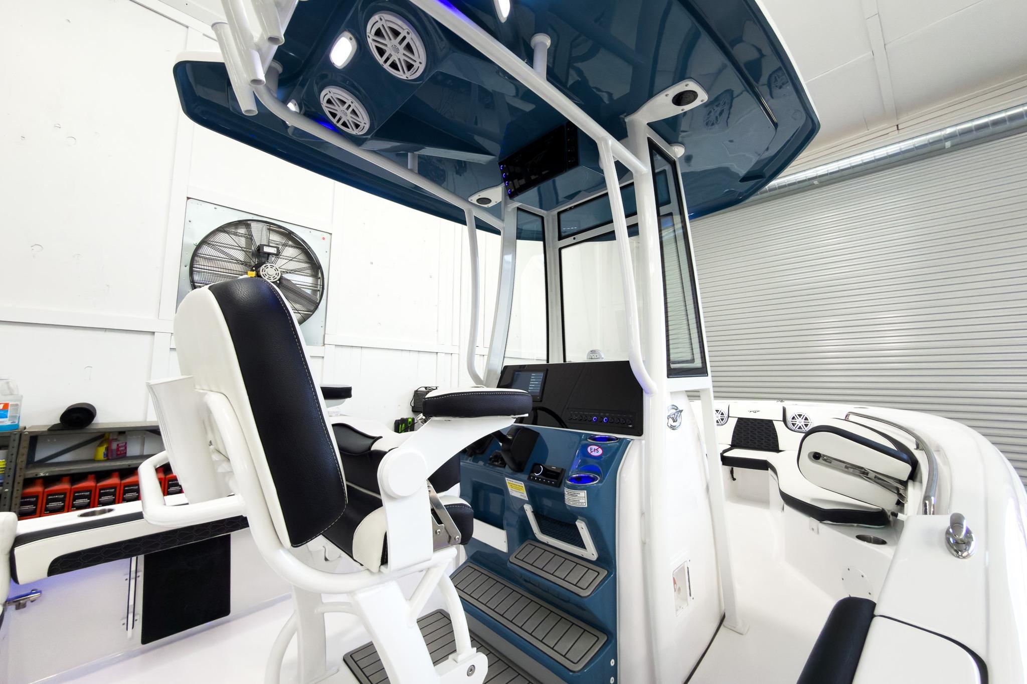 The image shows a modern boat cockpit with blue accents and a helm station.