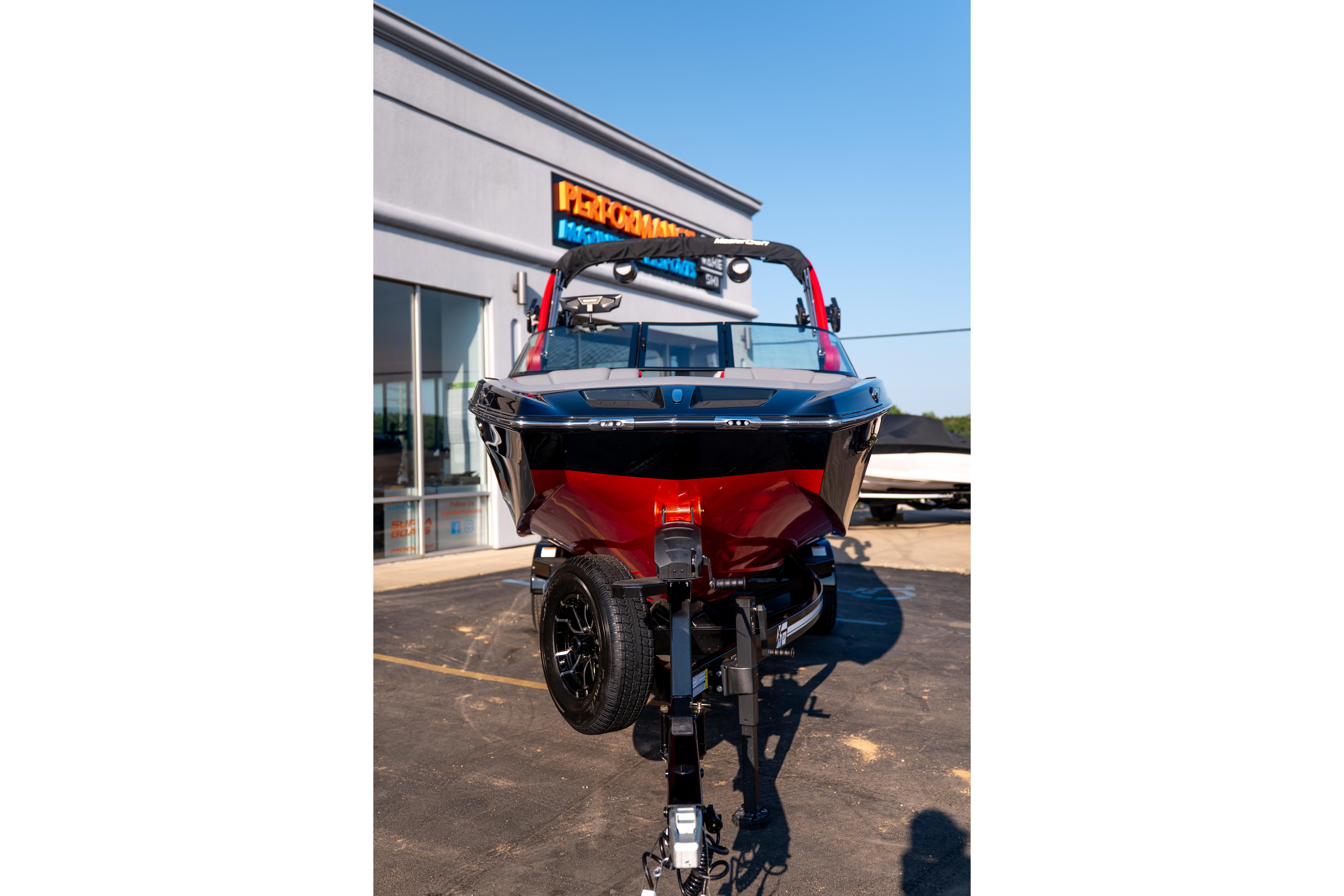 2027 MasterCraft XT24 boat on trailer outside dealership.