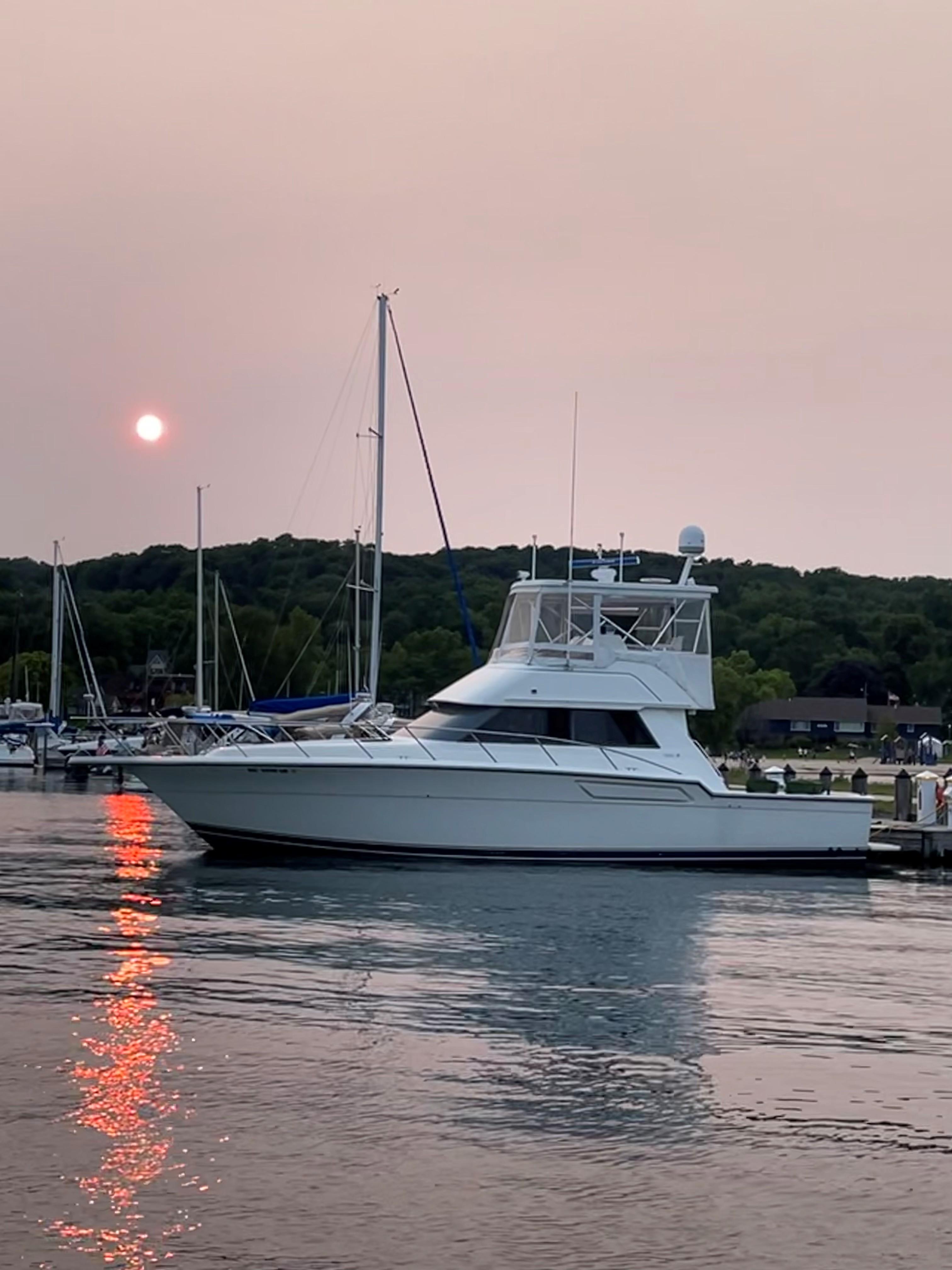 1990 Tiara Yachts 4300 Convertible docked at sunset, reflecting on calm water.