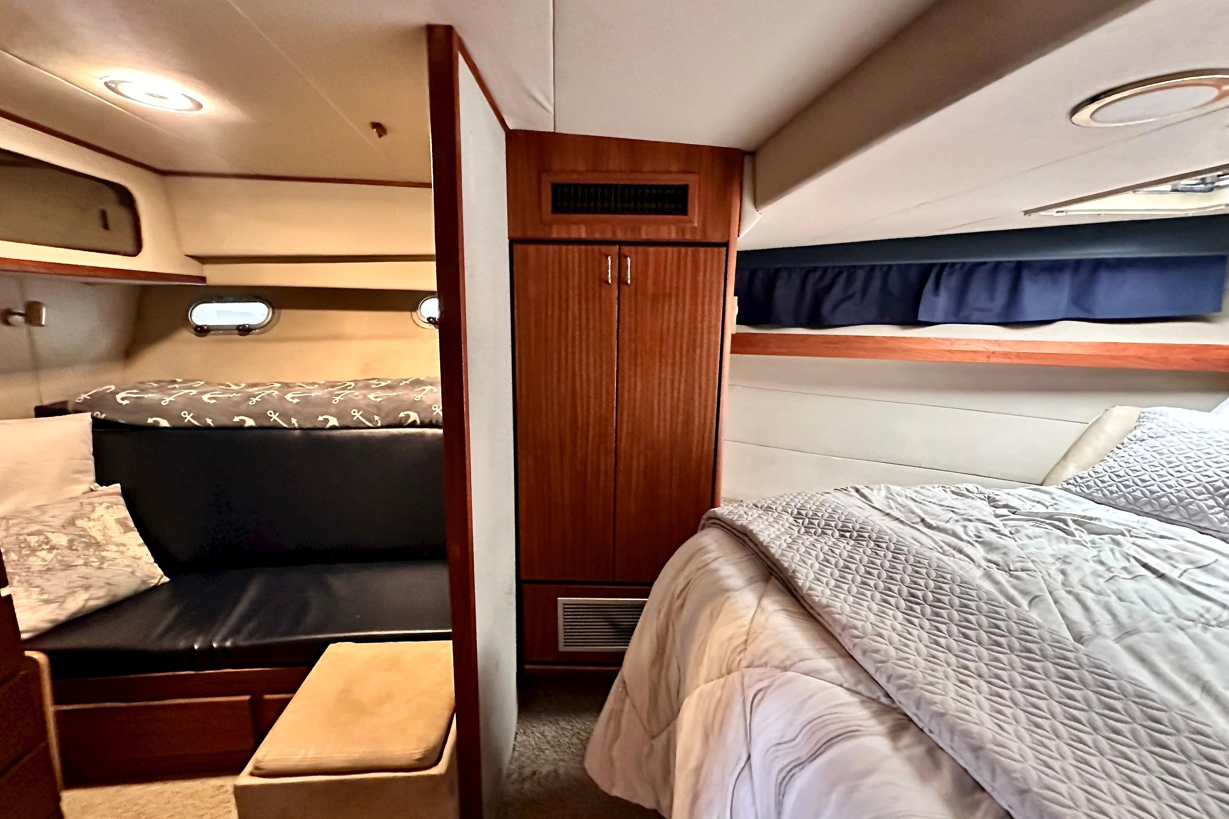 Cozy interior of 1993 Bayliner 4588 Pilothouse with bed, seating, and wooden cabinetry.