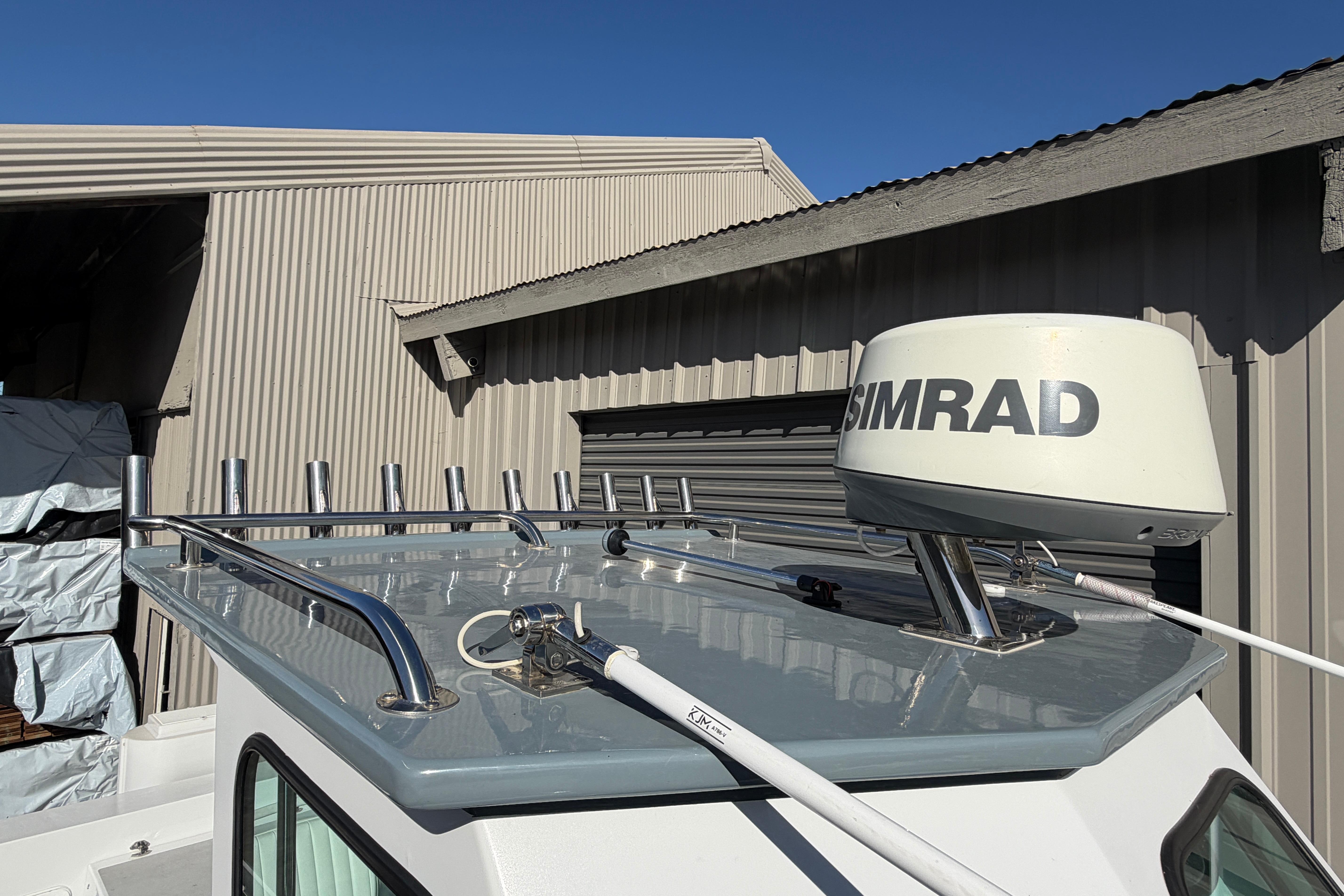 1986 Radon 21 Sport boat with Simrad radar, parked near a corrugated metal building.