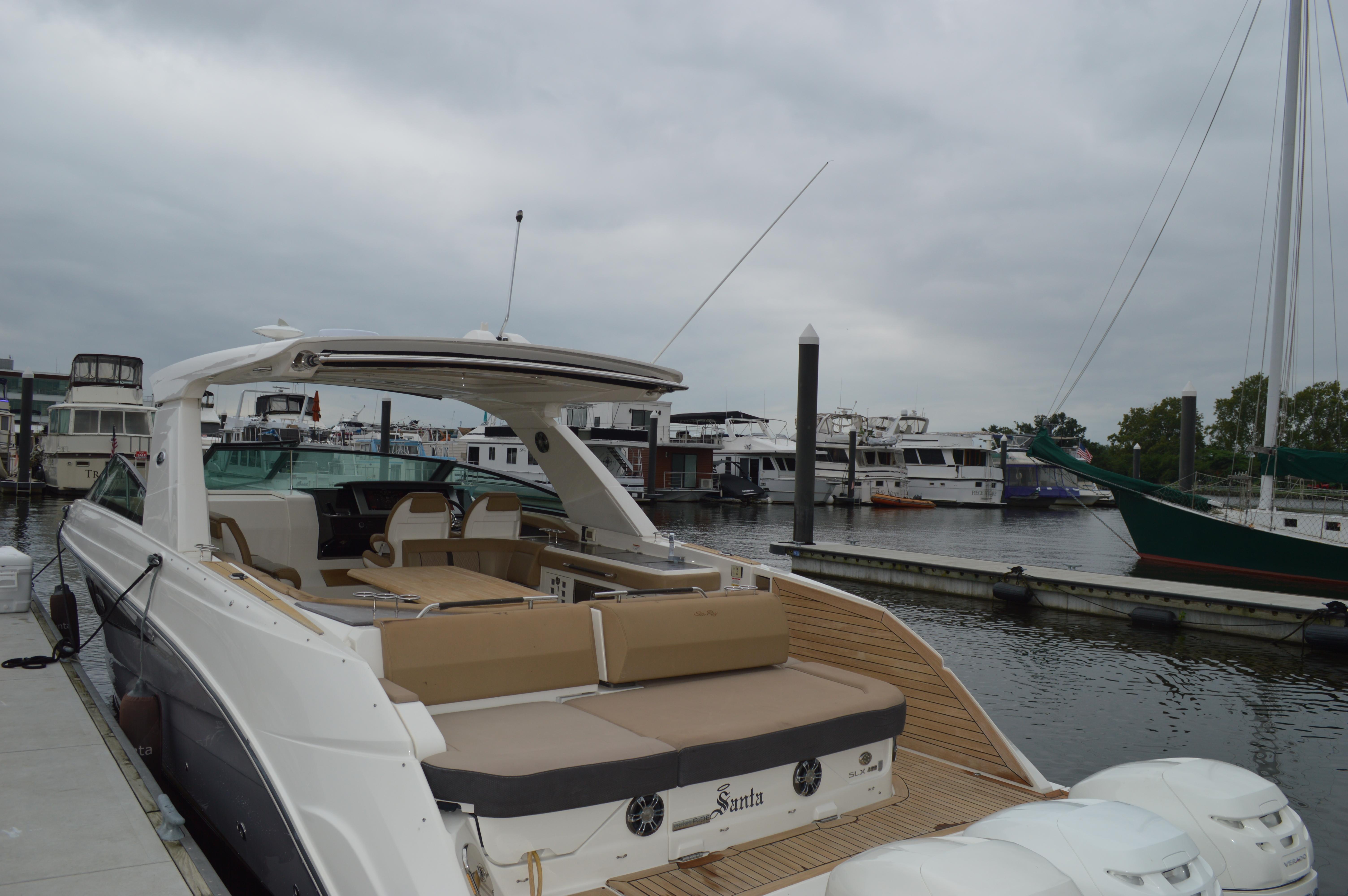 2019 Sea Ray SLX 400 Outboard docked at marina, featuring spacious seating and sleek design.