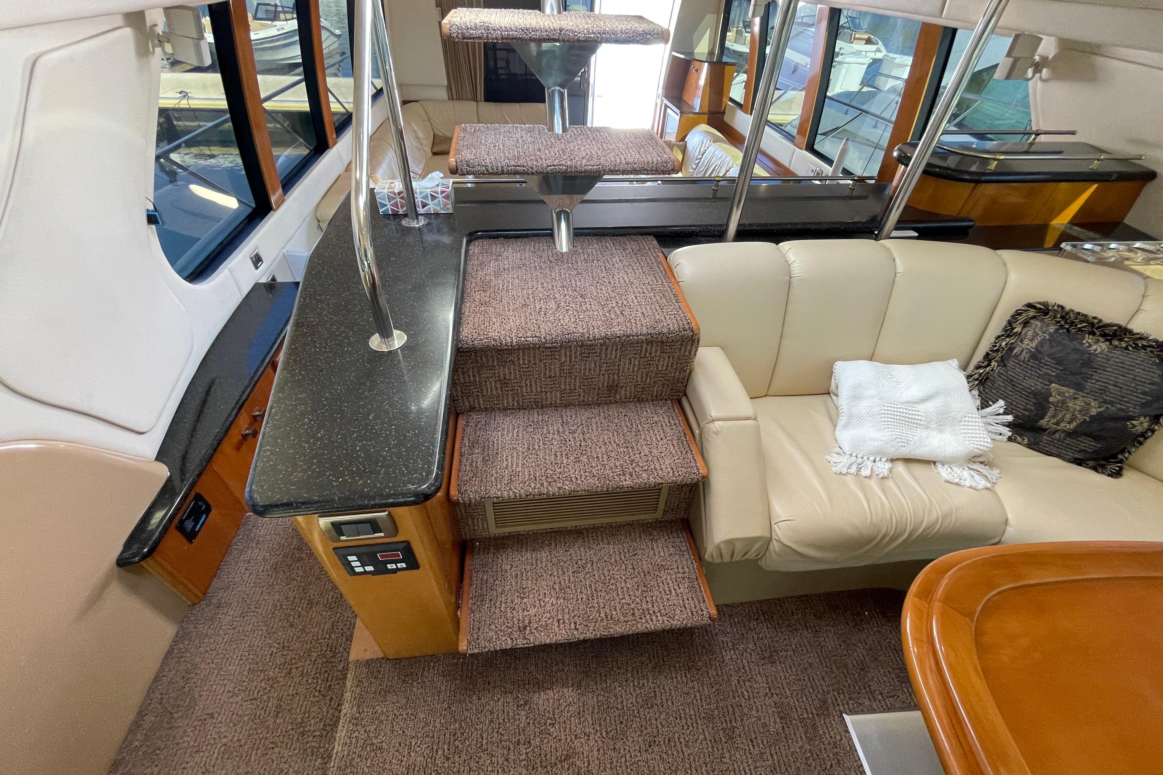 Interior of 2002 Carver 570 Voyager Pilothouse with stairs, seating, and elegant decor.