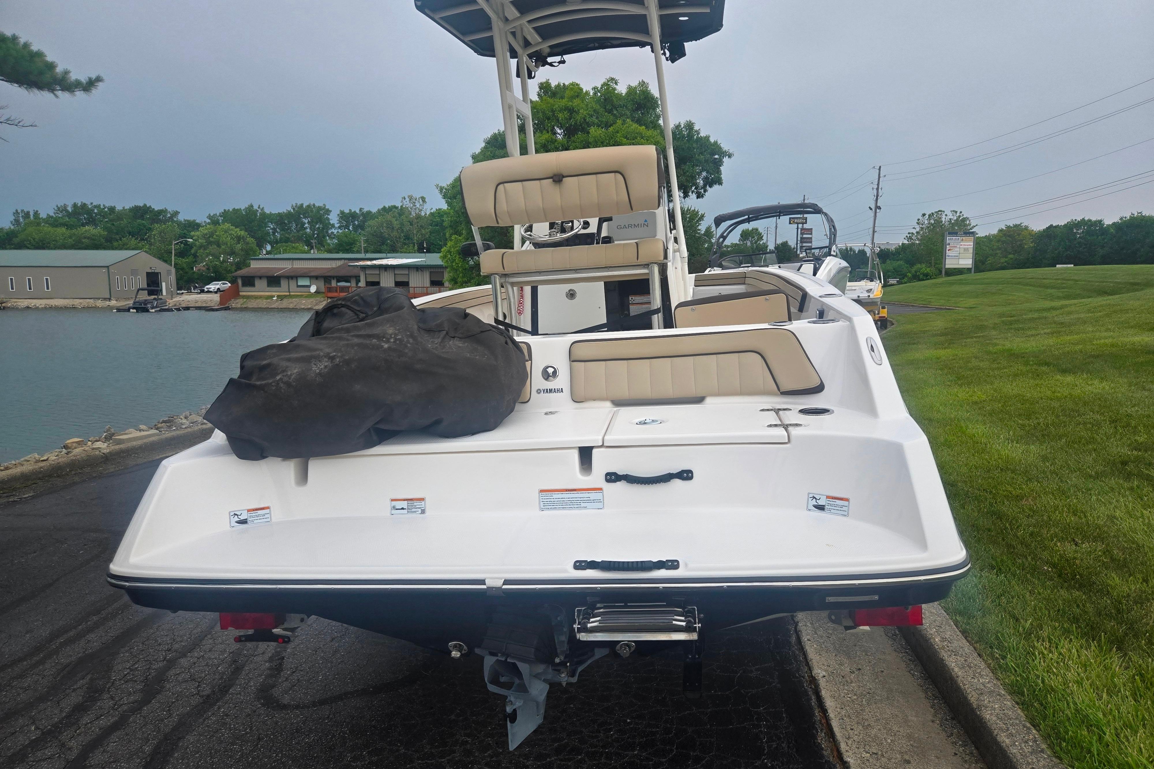 2022 Yamaha Boats 195 FSH Sport docked by a lakeside, showcasing rear view.