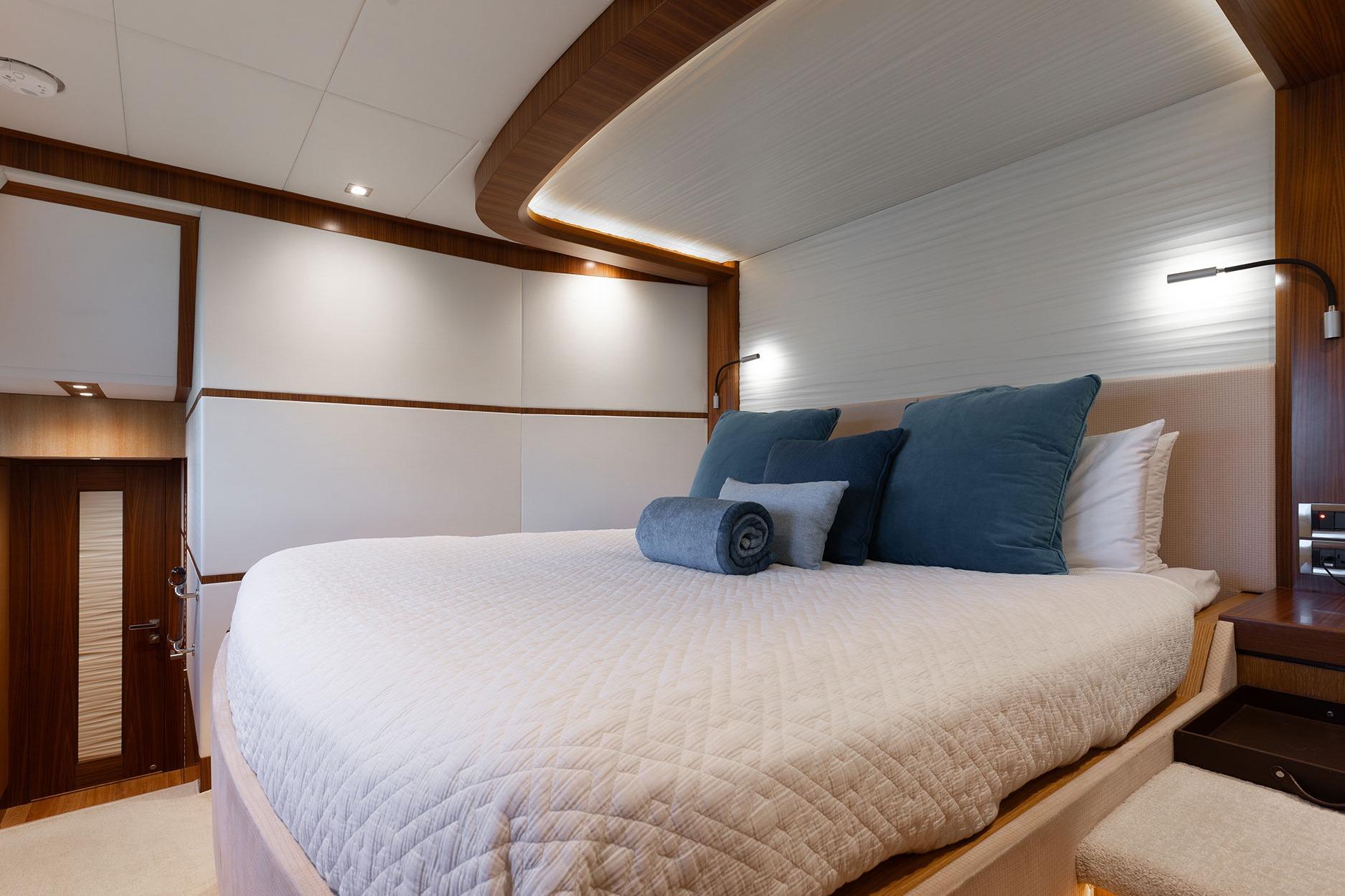 Luxurious bedroom interior on 2018 Horizon PC74 yacht with elegant bedding and ambient lighting.