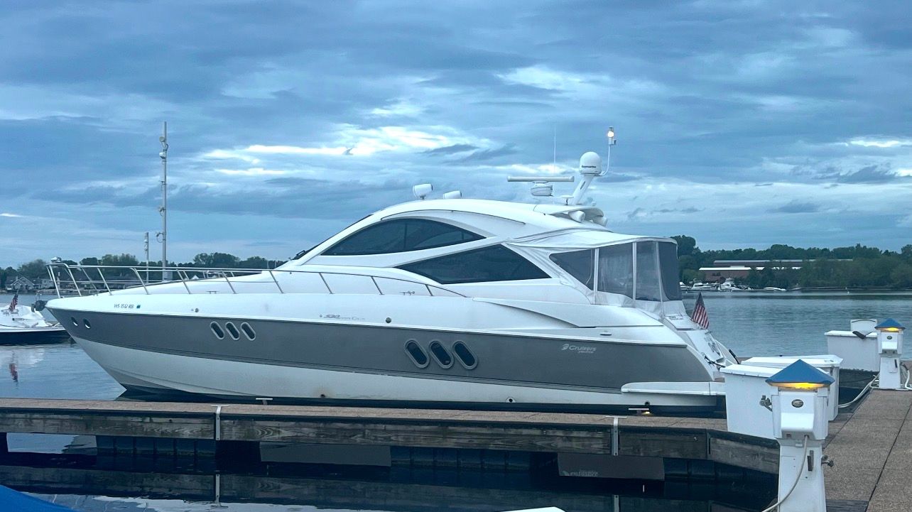 A 2009 Cruisers Yachts 520 Sports Coupe docked at a calm pier.