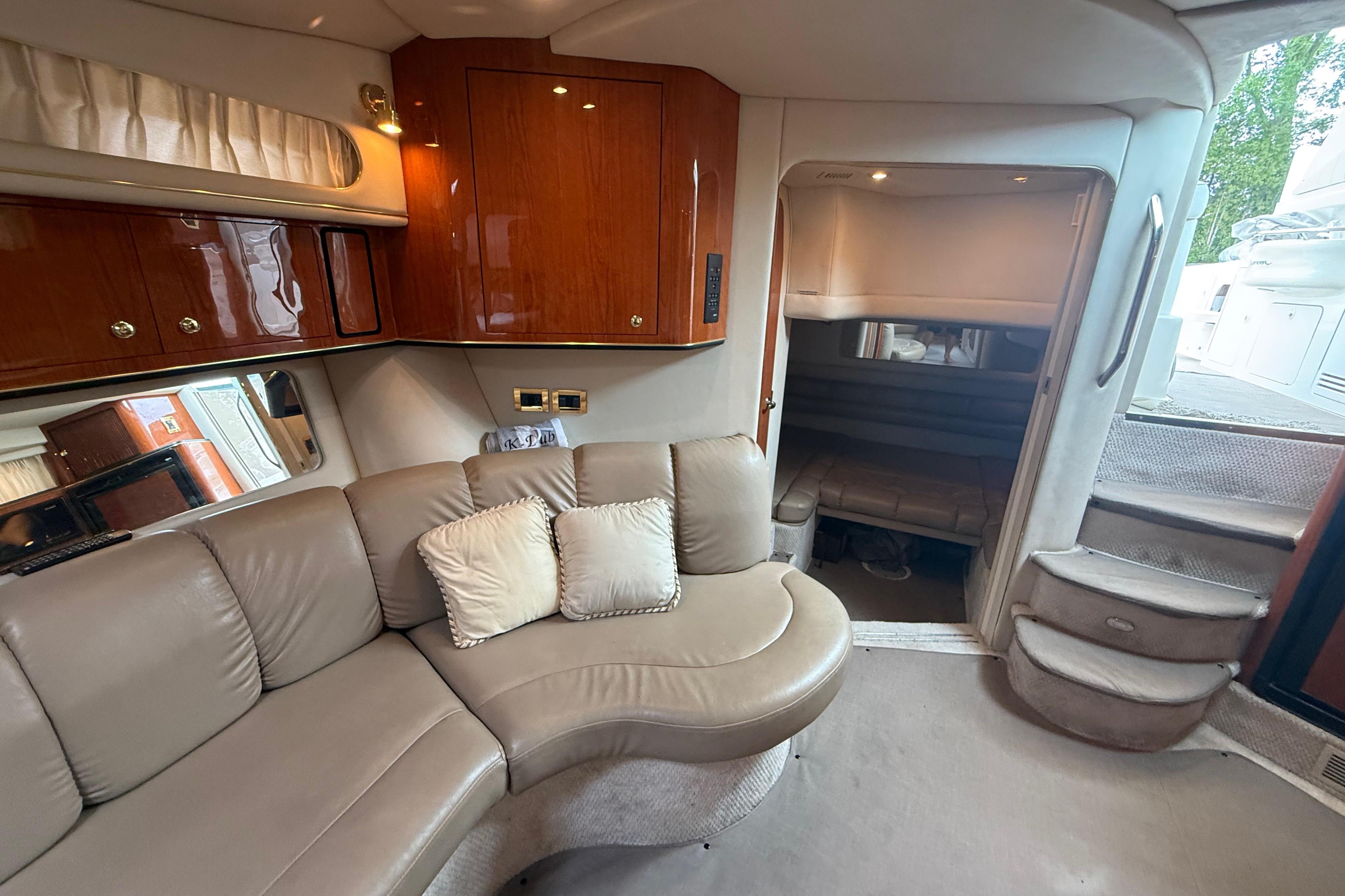 Interior of 1998 Sea Ray Sundancer 400 yacht with plush seating and elegant wood cabinetry.