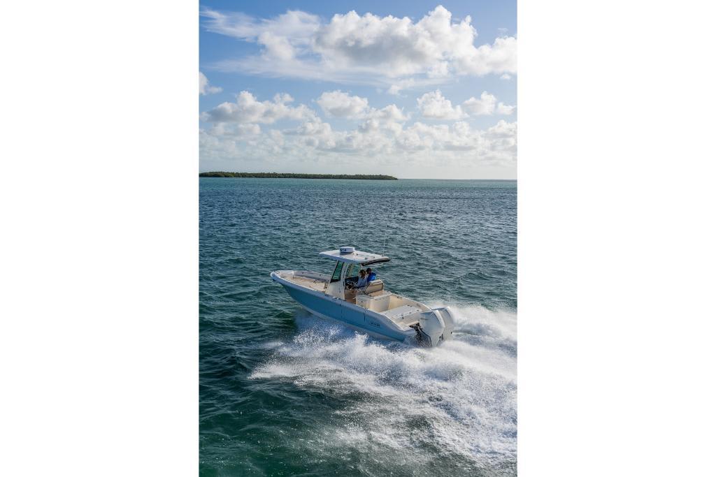 2024 Boston Whaler 280 Dauntless cruising on open water under a partly cloudy sky.