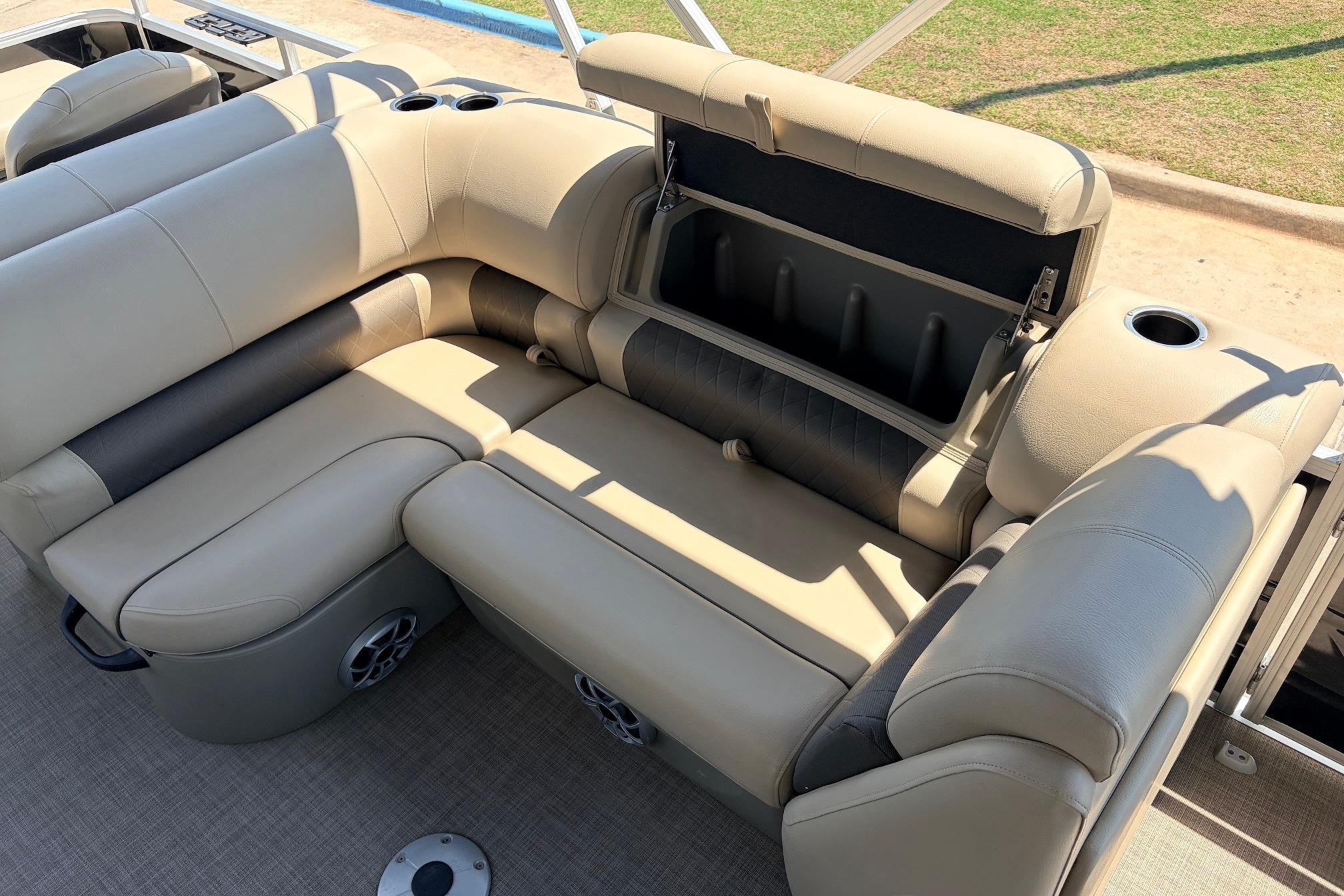 2024 Sun Tracker SportFish 22 XP3 pontoon boat with beige seating and storage compartment.