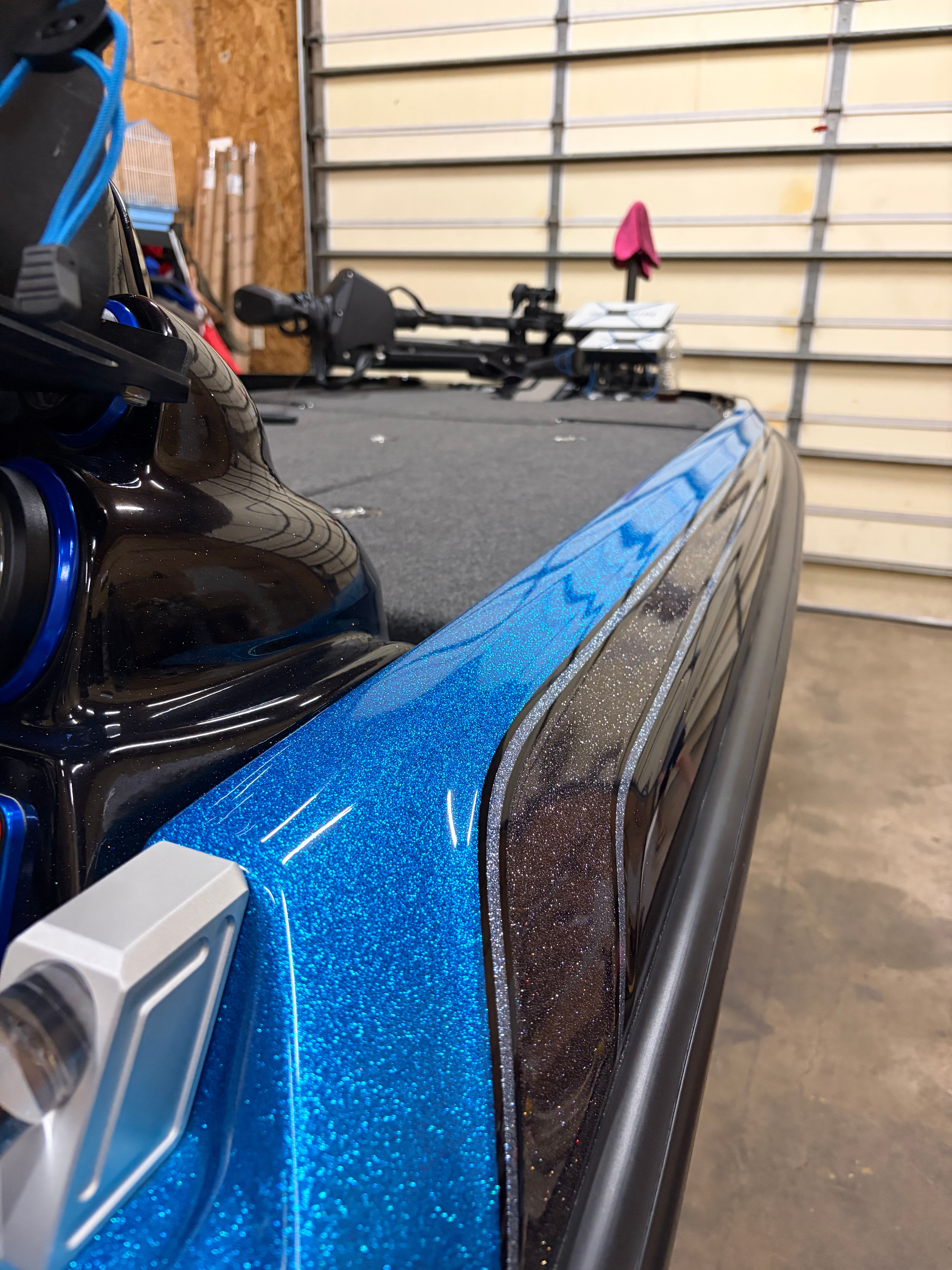 Close-up of a blue 2023 Bass Cat Cougar FTD with a glossy finish in a garage.
