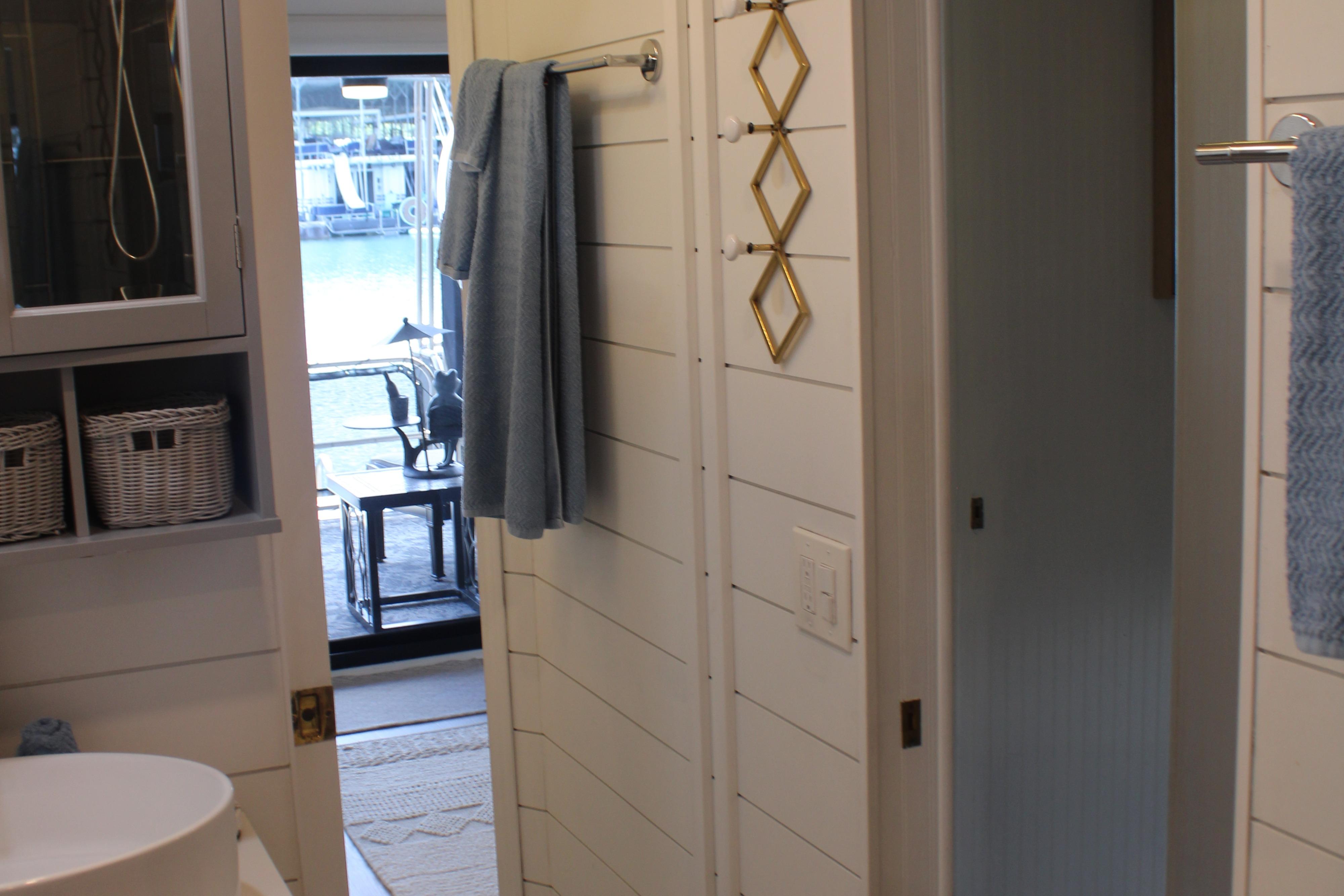 Bathroom interior of a 1992 Sumerset 66 houseboat with towels and wicker baskets.