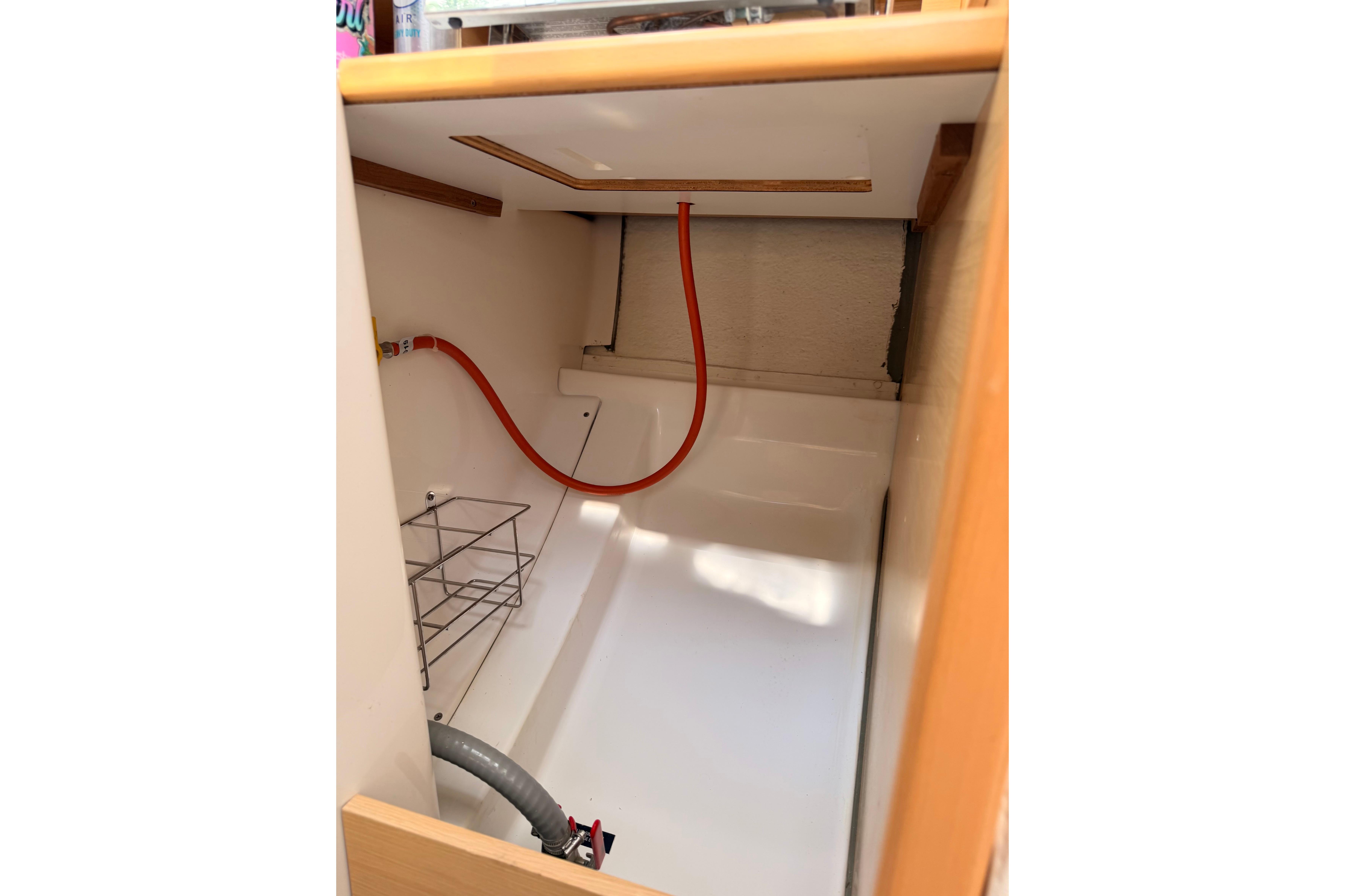 Interior view of a 2014 Beneteau FIRST 25 S sailboat, showcasing storage and piping.