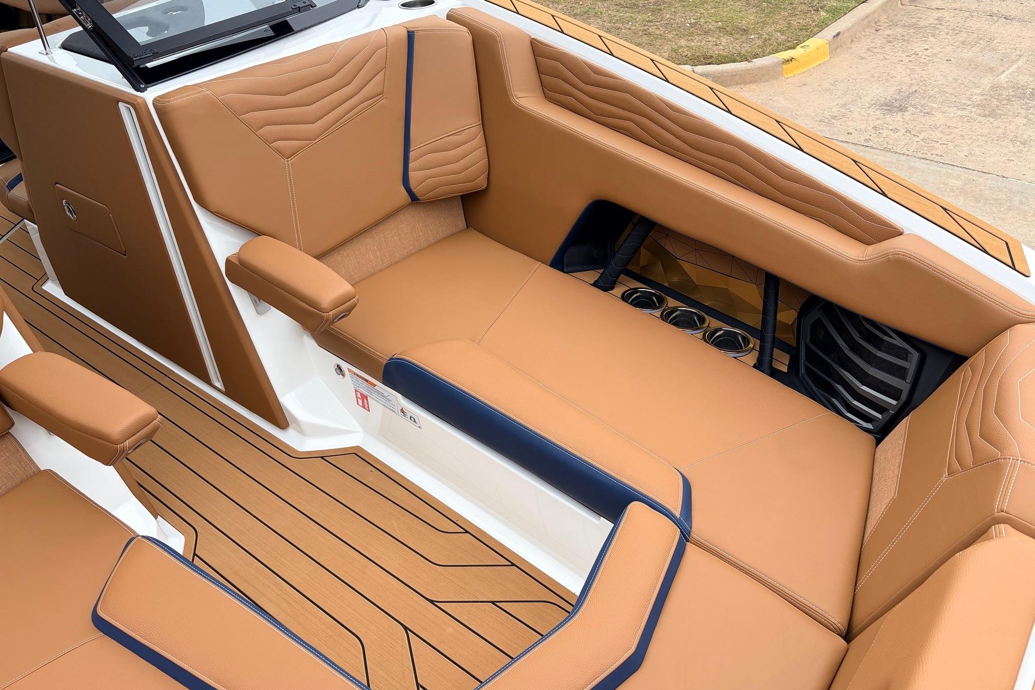 Luxurious interior of 2026 Nautique Super Air Nautique G25 with tan upholstery and cup holders.