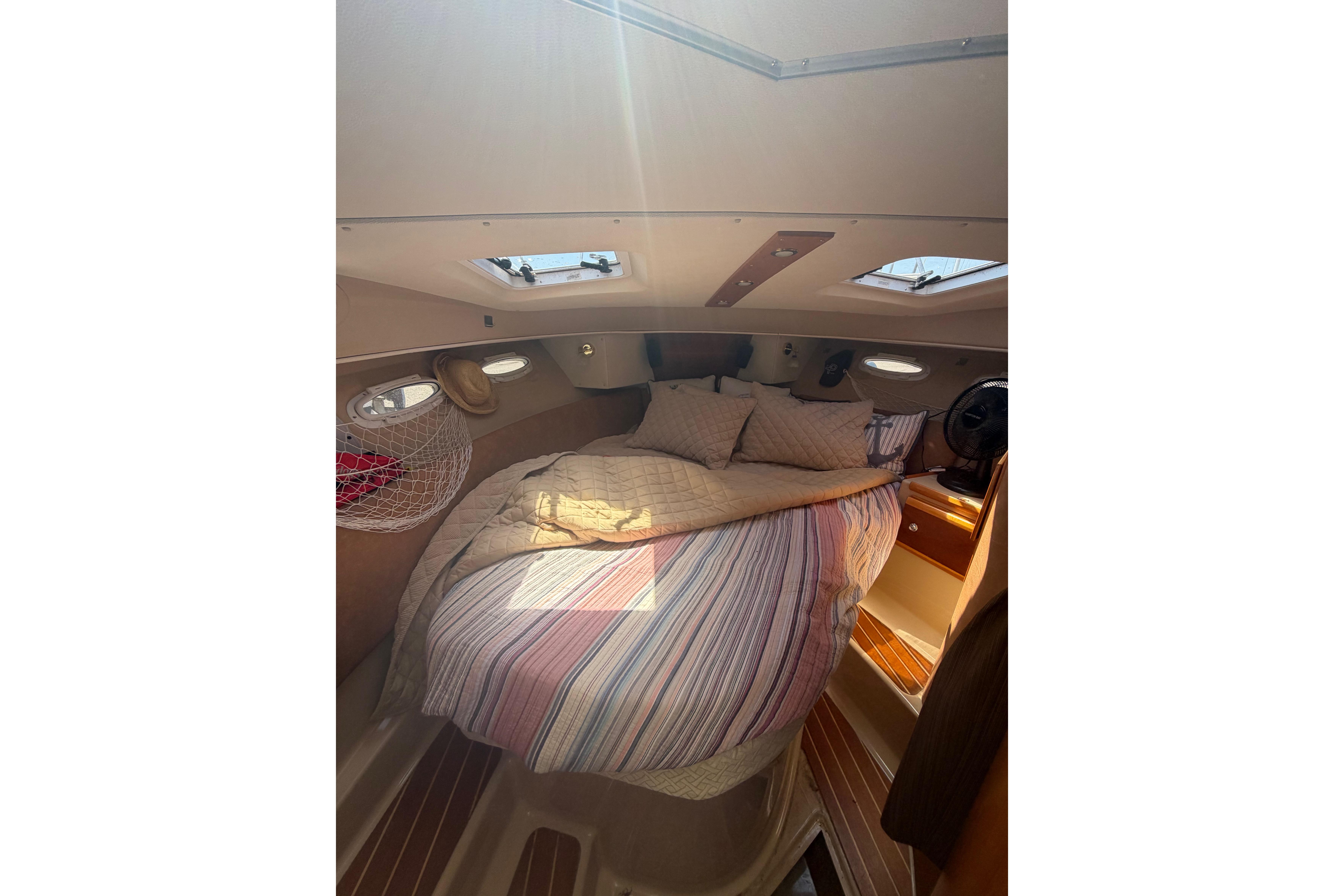 Cozy cabin interior of 2015 Cutwater C-30 Sedan with bed and natural light.