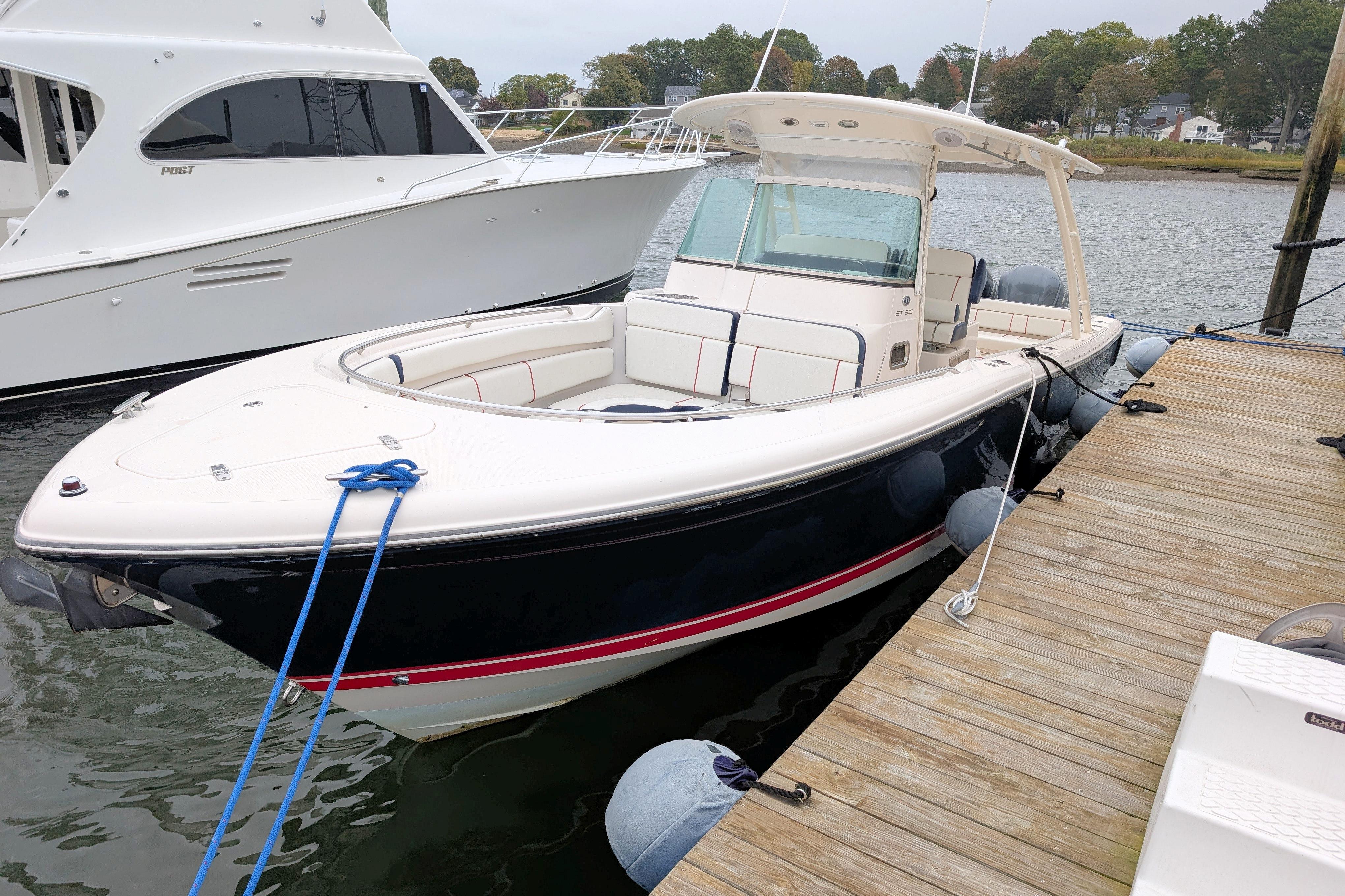 2013 Pursuit ST 310 Sport boat docked at a marina, side view.