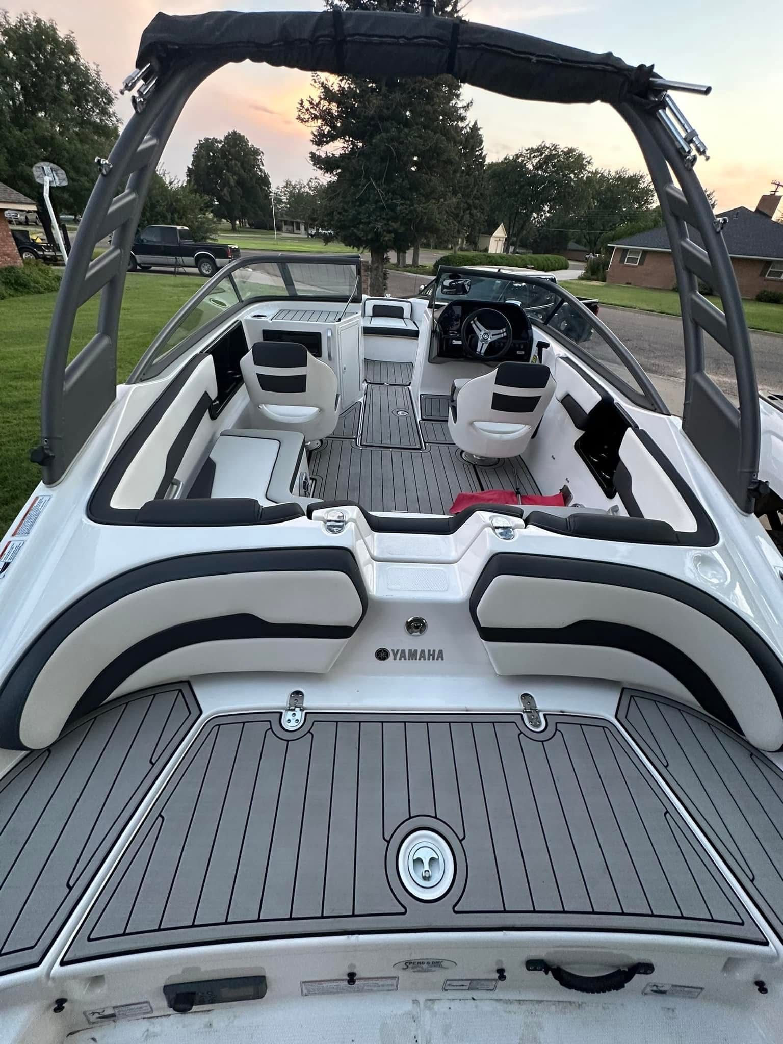 The image shows the interior of a 2020 Yamaha 195S boat with gray seating and flooring.