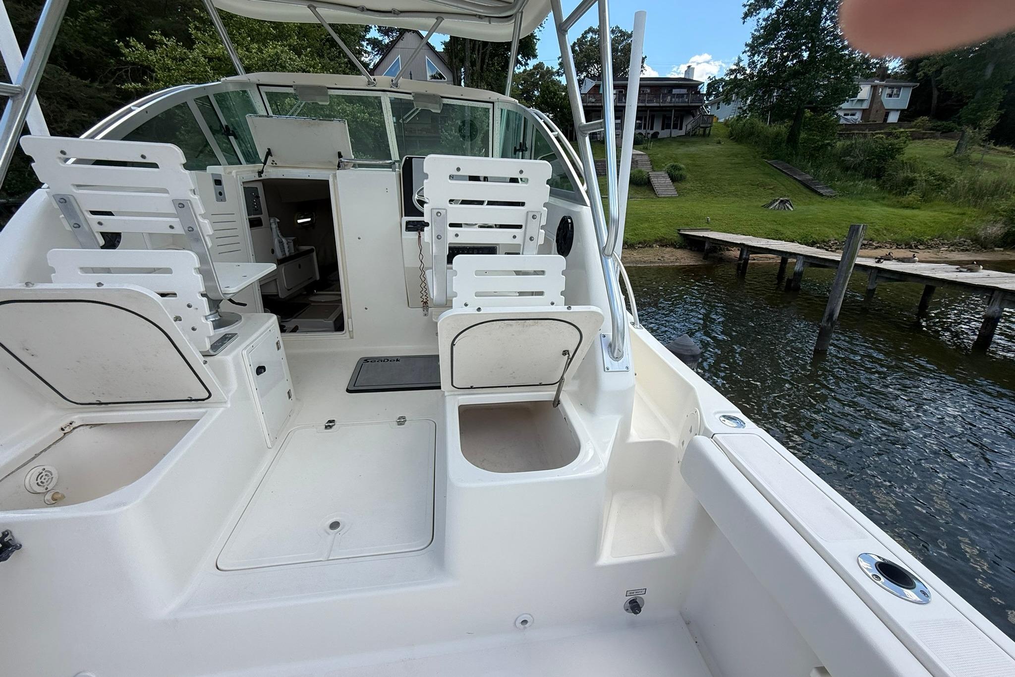 2003 Pursuit 2870 Walkaround boat interior with seating, docked by a lakeside.