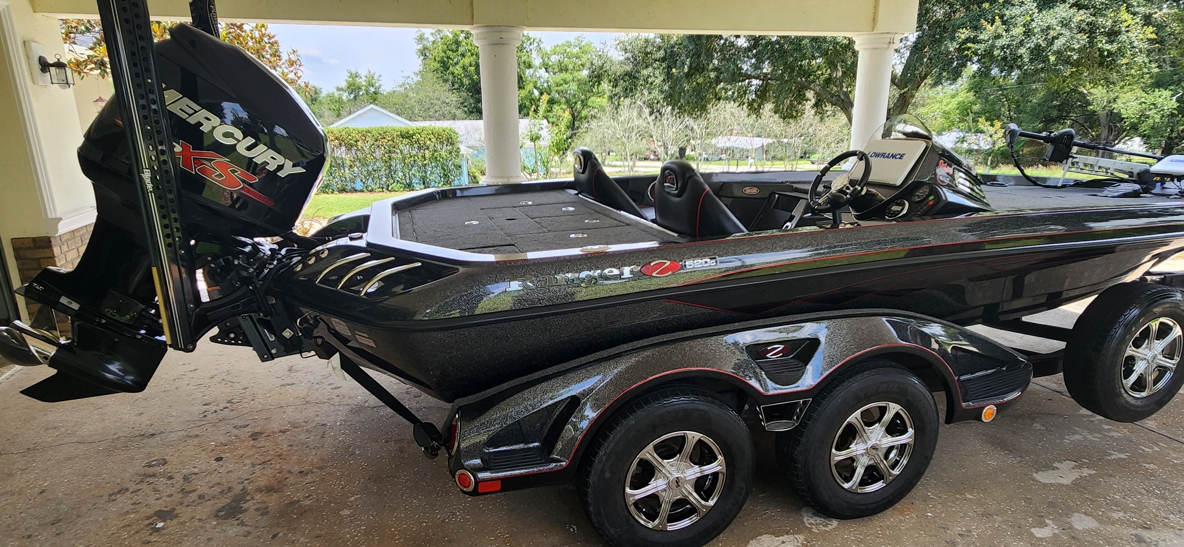A black 2017 Ranger Z520 Comanche boat on a trailer under a carport.
