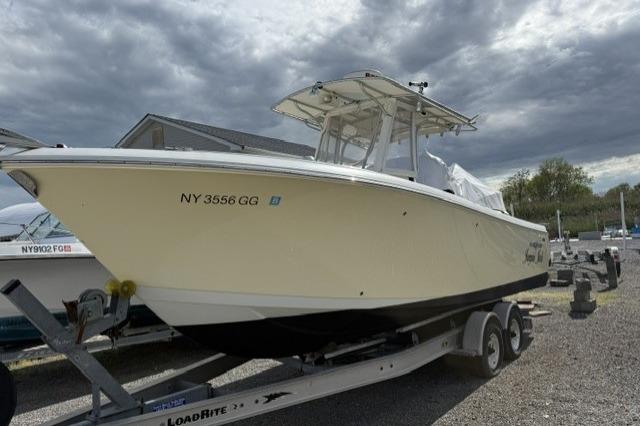 2006 Sailfish 2660 CC boat on trailer under cloudy sky.