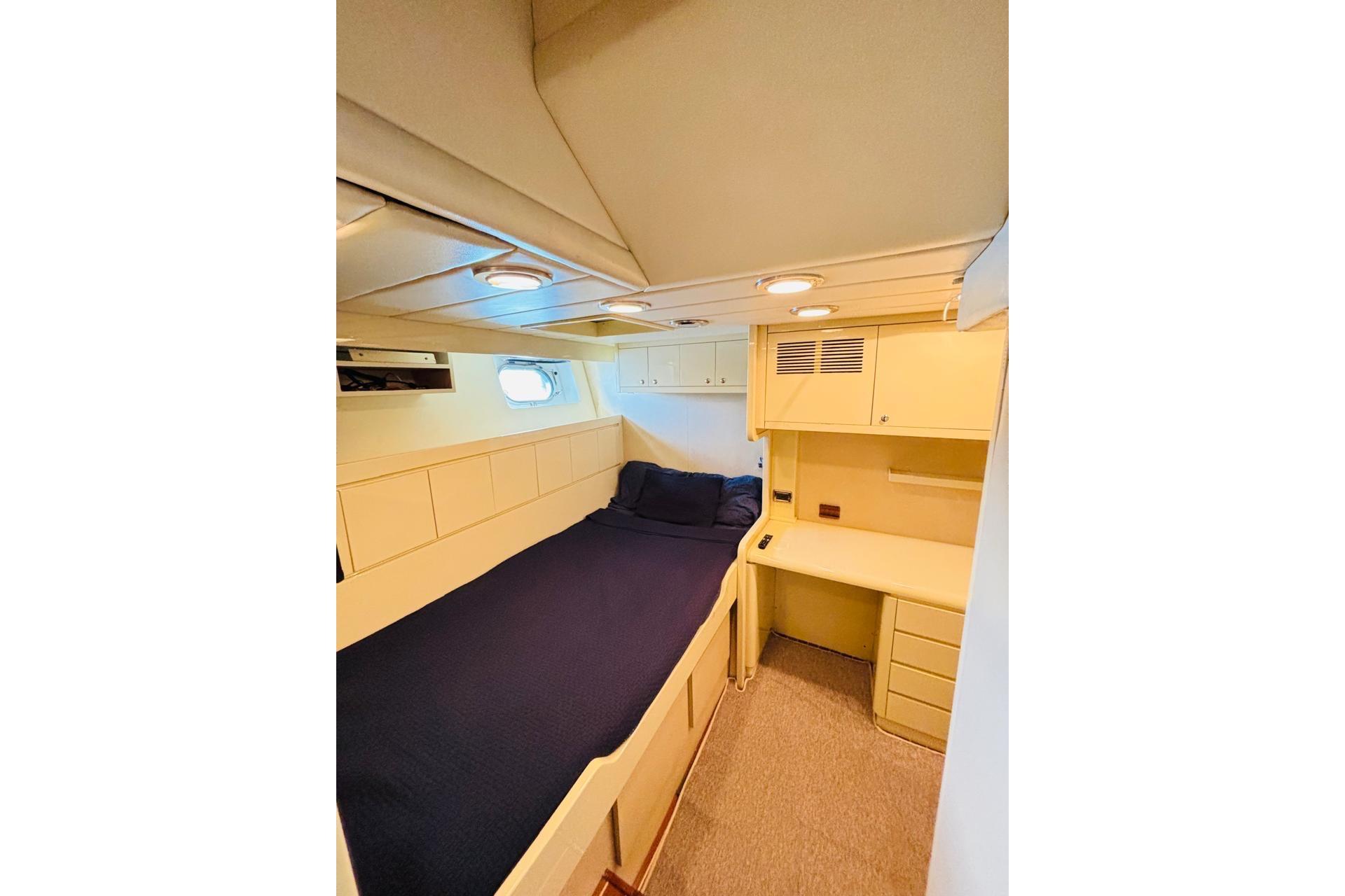 Cozy cabin interior of 2000 Falcon 100 yacht with bed and desk.