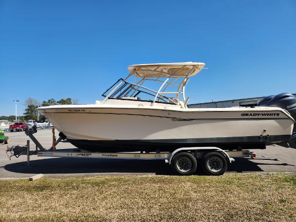 2015 Grady-White Freedom 275 boat on trailer, parked outdoors under clear blue sky.