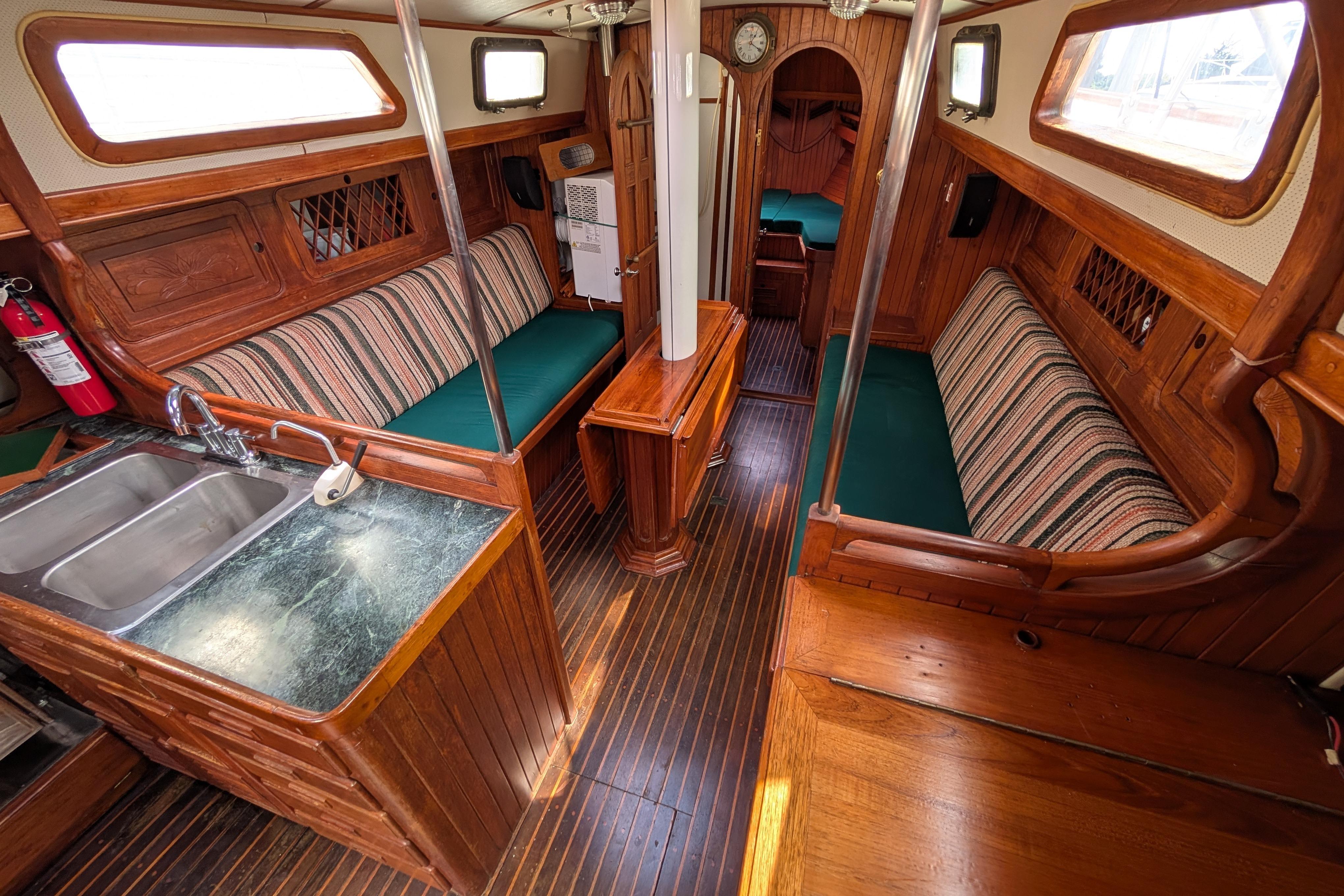 Interior of 1983 Perry 41 sailboat with wooden furnishings and striped seating.