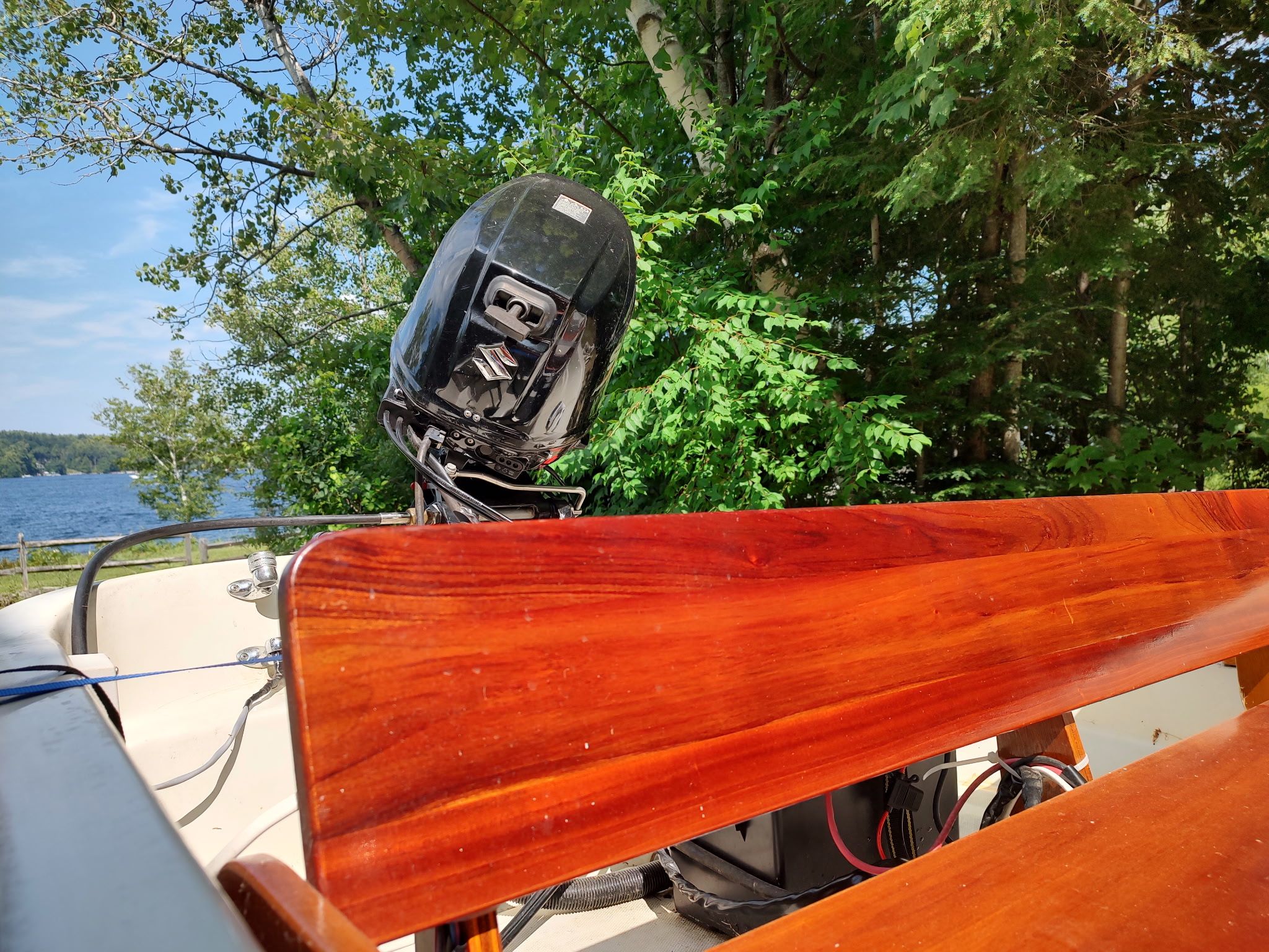 A 1987 Boston Whaler Sport 13 with an outboard motor, surrounded by trees and water.