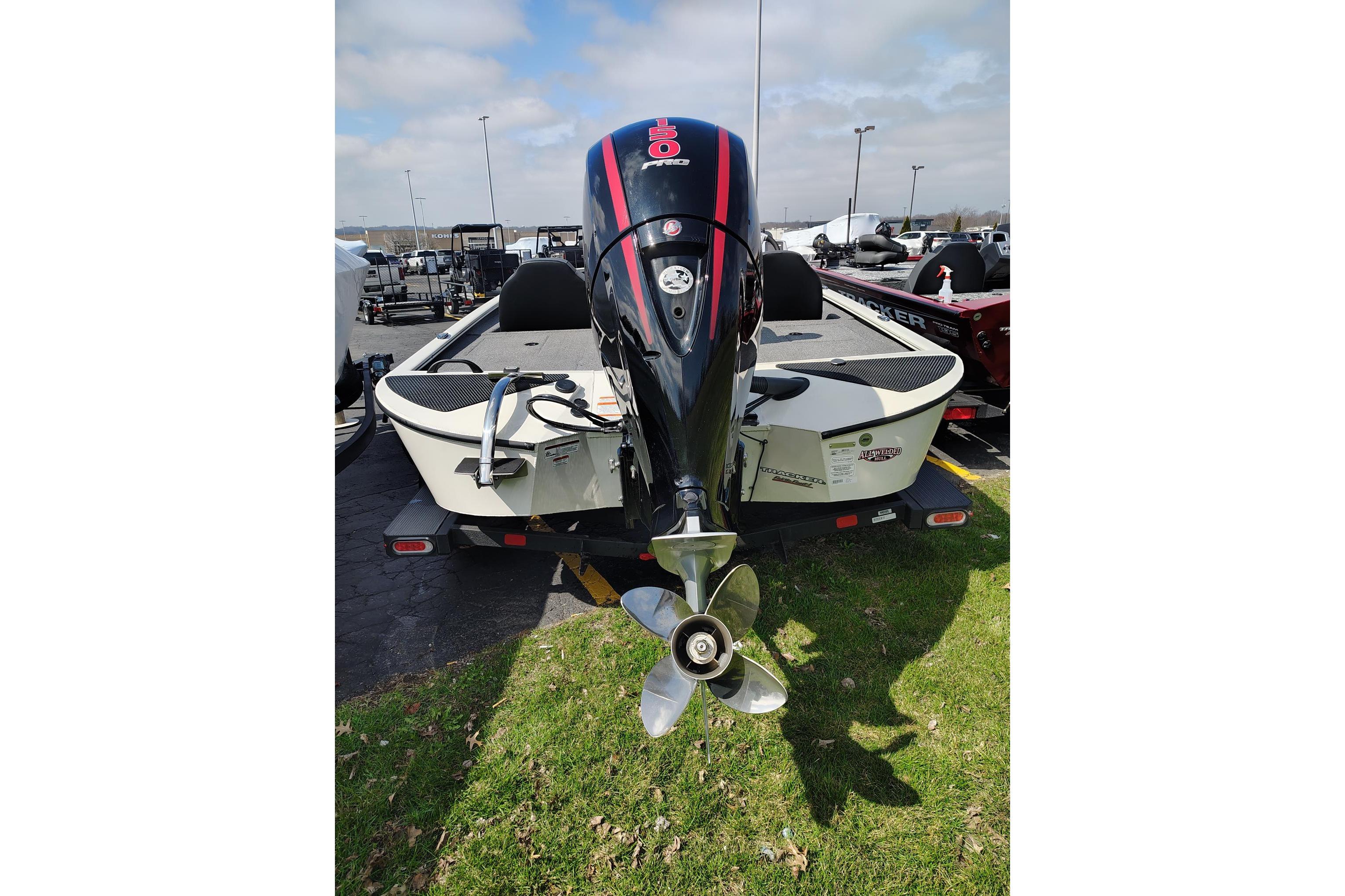 2025 Tracker Savage 215 boat with powerful outboard motor, parked on grass.