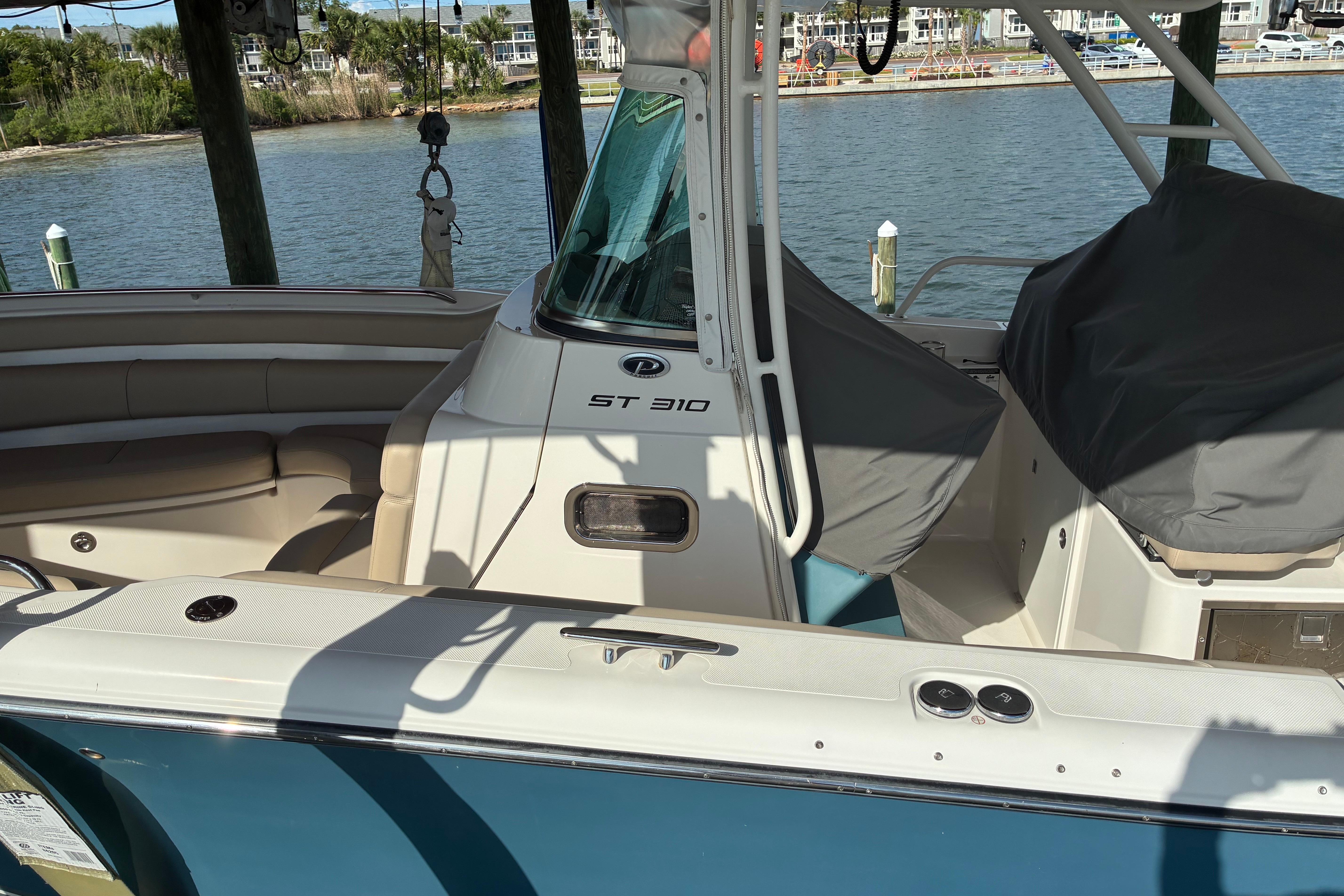 2015 Pursuit ST 310 Sport boat docked by the water.